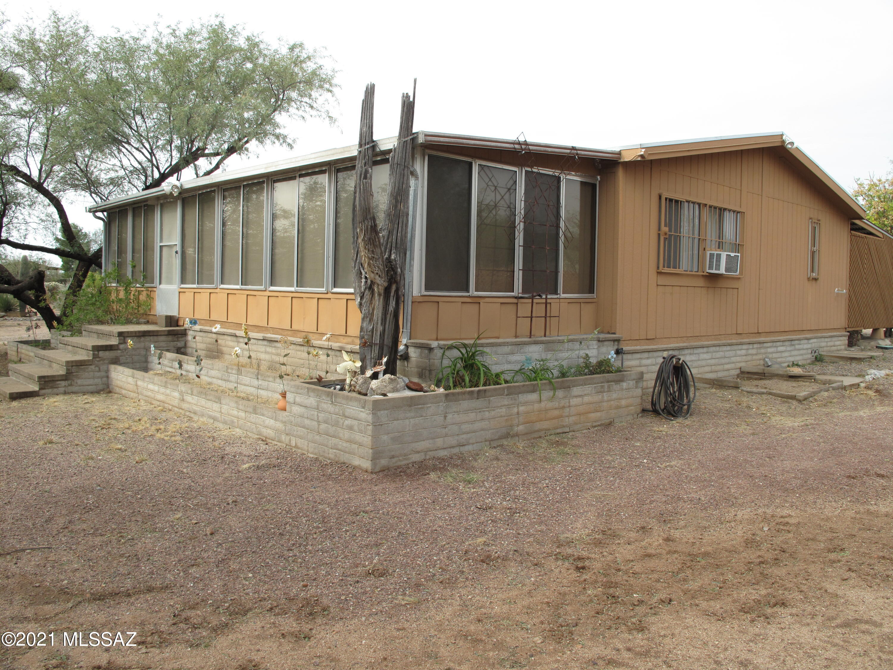 Here is your opportunity to find something that satisfies everyone. Beautiful home, located on a one acre lot, zoned for horses-fully and fenced.   Recently remodeled kitchen with new cabinets, Corian counters, backsplash and appliances. Enclosed Arizona room and covered rear patio with a waterfall, so there are lots of places to enjoy the outdoors. And...lovely mountain views