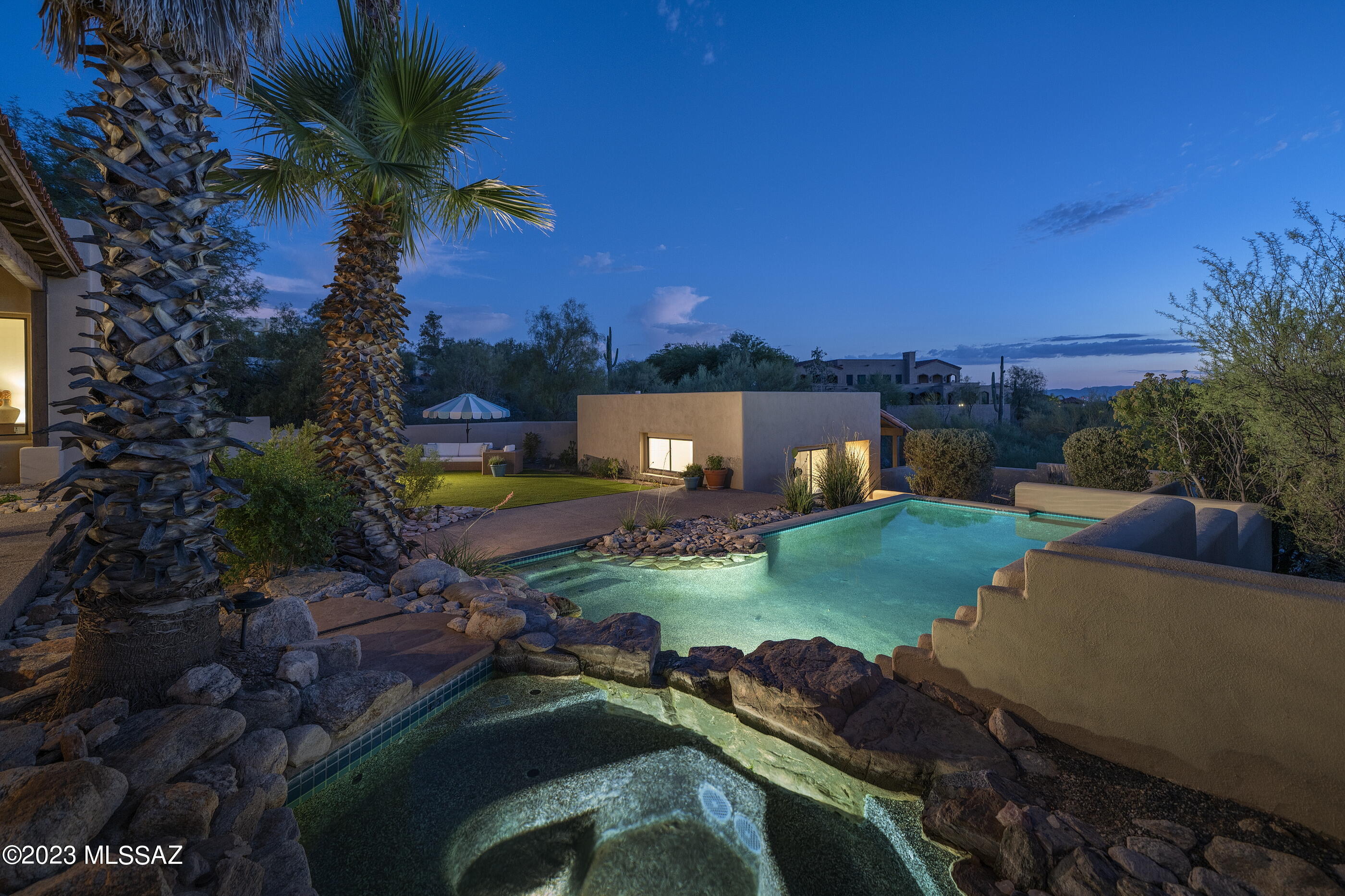 Enjoy Catalina Mountain views, city lights, and fabulous sunsets from this hillside residence on a private cul-de-sac within the gated community of Colonia Del Sol. The courtyard entry leads to a flowing floor plan that includes a sunken living room, dining area with coved ceiling, and spacious family room featuring a beehive fireplace and walls of windows. The spacious kitchen offers gorgeous solid wood cabinetry, Corian countertops, Saltillo tile floors, and a light-filled breakfast nook with captivating mountain views. The split layout of the residence provides a private primary bedroom sanctuary offering a spa-like bathroom with jetted tub and separate shower, large walk in closet, and sliding glass doors leading to the patio. The balance of the 3 bedrooms and 2 full bathrooms in the main home are sequestered on the opposite wing, perfect for families or guests alike. 

The privately situated guest casita offers a spacious bedroom area and kitchenette, bathroom, and a private covered patio to enjoy the sweeping views. 

An expansive main-house patio connects the shared living spaces, ideal for seamless indoor-outdoor entertaining or al fresco dining. Layers of elevated lounge areas create the framework for the luxurious PebbleTec pool and spa, acting as the centerpiece of the backyard. 

Ultra-privacy meets convenient proximity to all of life's necessities. From this central Foothills location, one is just moments away from hiking and biking trails, Hacienda Del Sol Resort, La Paloma Country Club, and La Encantada's shops and restaurants.