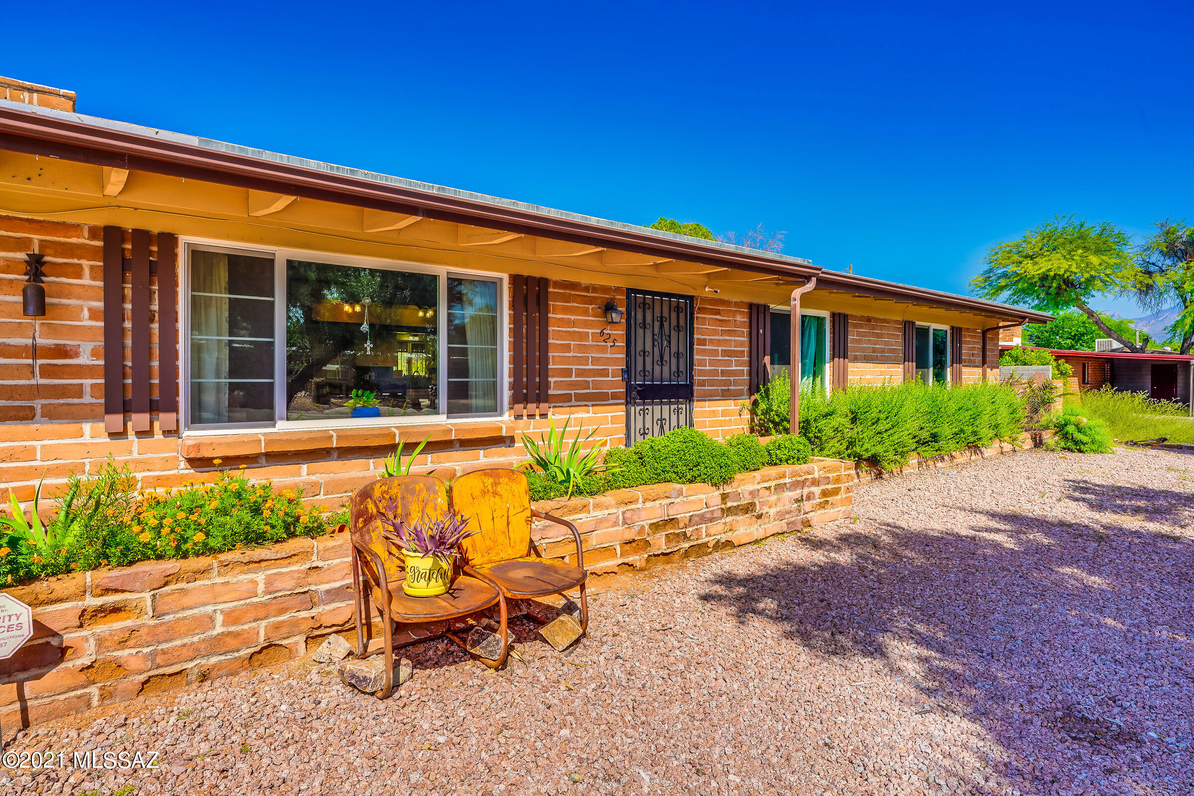 Range Priced between $300,000 and $325,000.  Beautiful Atomic Mid-Century Adobe Ranch.  Perfect for large-family living in a quiet, established neighborhood.  NO HOA! Make it your own!

The 2018 remodel included a lovely kitchen renovation, new hardwood and ceramic tile flooring throughout home, new east-facing dual pane windows, and a new roof. The kitchen/dining area has white shaker cabinets with black granite countertops and great open floor plan. Natural wood beam ceiling in living room and family room. Living room features a large picture window and floor-to-ceiling red brick, wood-burning fireplace. Two bonus rooms in back for office and crafts or whatever you dream of. Large walkthrough laundry room with a full wall of storage! Washer, dryer and second refrigerator do not convey. Block wall surrounds entire back yard and backs up to a minor wash for privacy. Covered patio and brick courtyard are a great place for you to relax. Both large backyard sheds convey. Very desirable quiet neighborhood in the heart of Tucson, close to schools, medical facilities and bus line.