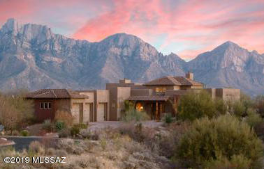 Breathtaking Santa Catalina views as a backdrop for this perfect size southwestern style home. Located in the prestigious Estate of Honey Bee Ridge. Perched high on 1.45 acres surrounded by saguaro-studded hills. Walls of view windows and soaring ceilings bring outdoor beauty inside! Easy flowing floor plan with incredible finishes and delightful attention to detail. Granite-gourmet kitchen with newer appliances opening to family room and fireplace w/views to lush backyard. Split floor plan with wonderful guest wing, two bedrooms and its own private den for gathering/reading and full private bath. Spacious master suite with private door to patio and luxurious master bath with two large walk-in closets. Four bedrooms or three bedrooms plus den, over-sized three car garage. Inviting oasis backyard with large covered patio, beautiful pool, spa, and waterfalls, outdoor kitchen, great for entertaining.  Built with the highest quality of craftsmanship.  Former builder model with many upgrades. This home has been meticulously maintained.