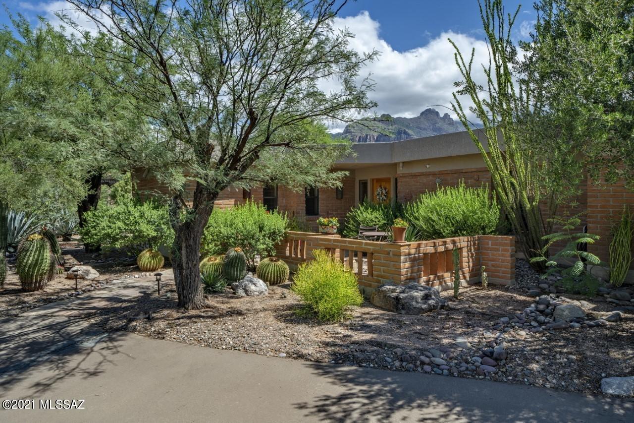 Charming updated Burnt Adobe Territorial in sought-after Catalina Foothills Estates #9 w/ gorgeous unobstructed mountain views. 4 BR/3 Bath split plan w/remodeled kitchen offering white cabs, Caesarstone counters, Stainless appliances, island w/breakfast bar, beverage station with coffee maker & wine frig. Concrete flooring in main living areas, Saltillo in Family Room. Light and bright, this home offers Solar + tons of charm with 2 fireplaces w/bancos, adobe accent walls & wood-plank ceiling in FR. Guest bedroom w/fireplace; 4th BR/Office w/Knotty Cedar desk/bookshelves & ensuite bath makes perfect guest quarters. 1.55 Acre cul-de-sac lot offers views, privacy and lush vegetation, Beehive Fireplace, multiple sitting areas, waterfall & hot tub. This home is truly special.