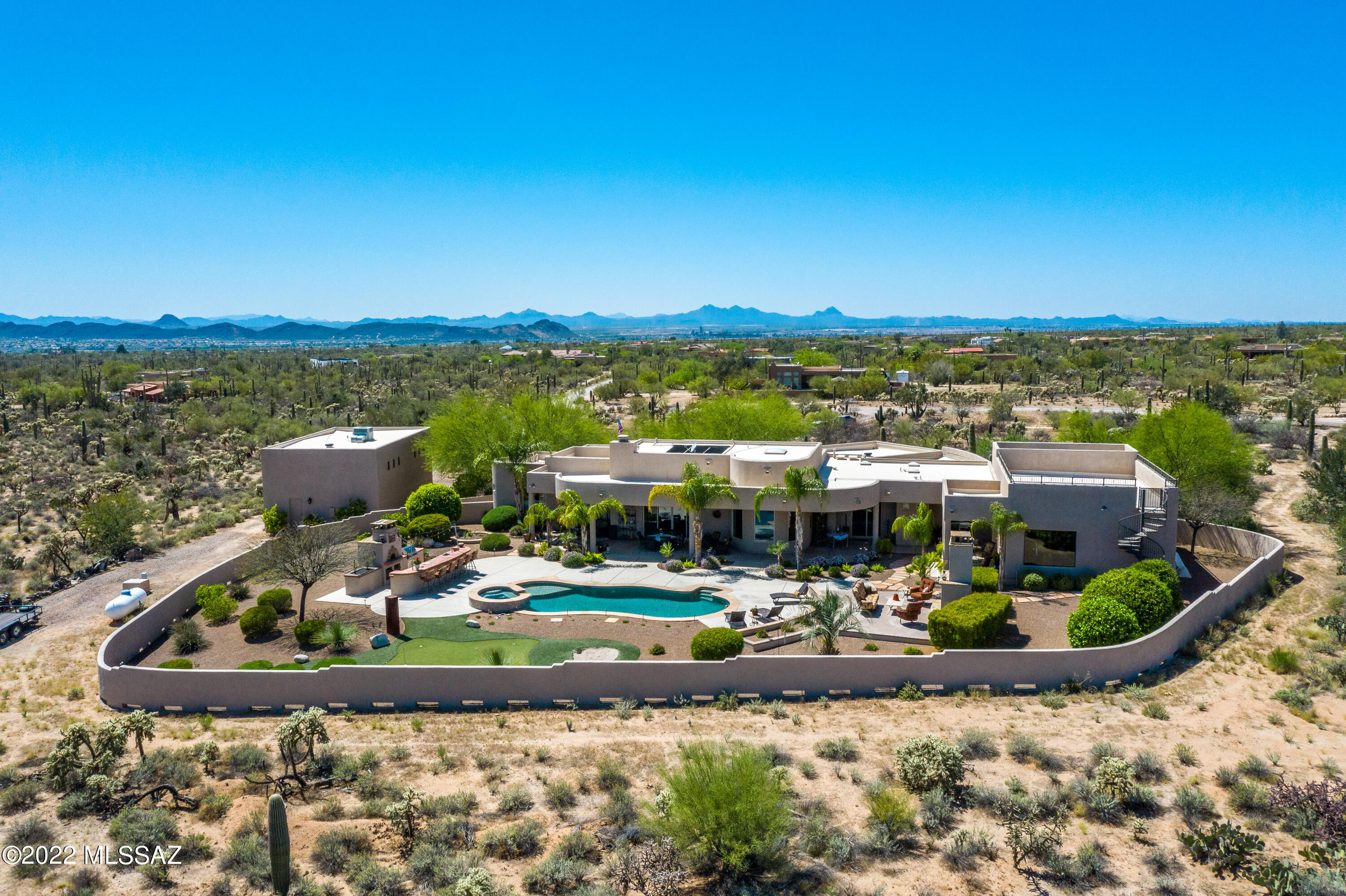 This property has it all. Outstanding mountain views, great privacy, beautiful pool & spa, grandest of outdoor living areas including putting green w/sand trap, stone fireplace, outdoor kitchen & bar, guest quarters/house attached to main home with its own living & dining areas separate bedroom, gym. Backyard is fully walled.  And best of all - one of the largest RV garages - can hold most likely 4 vehicles or one of the longest/tallest RV's.  Interior has no steps - has 3 bedrooms set up plus a spacious bonus room/office/den or additional bedroom.  Home is spectacular - grounds are gorgeous - including the gated from entry which welcomes you with tranquility,  This is a one of a kind location of privacy, no HOA, abundant storage for vehicles/boats/RV. There is a private well agreement wit a large money surplus in the account. There is also a road maintenance agreement. Much privacy - much beauty - and all the amenities anyone would want.  The guest house has a spiral attached staircase which will bring you even more stunning views.   Pool has solar heating which is owned outright. Call for a private showing.
