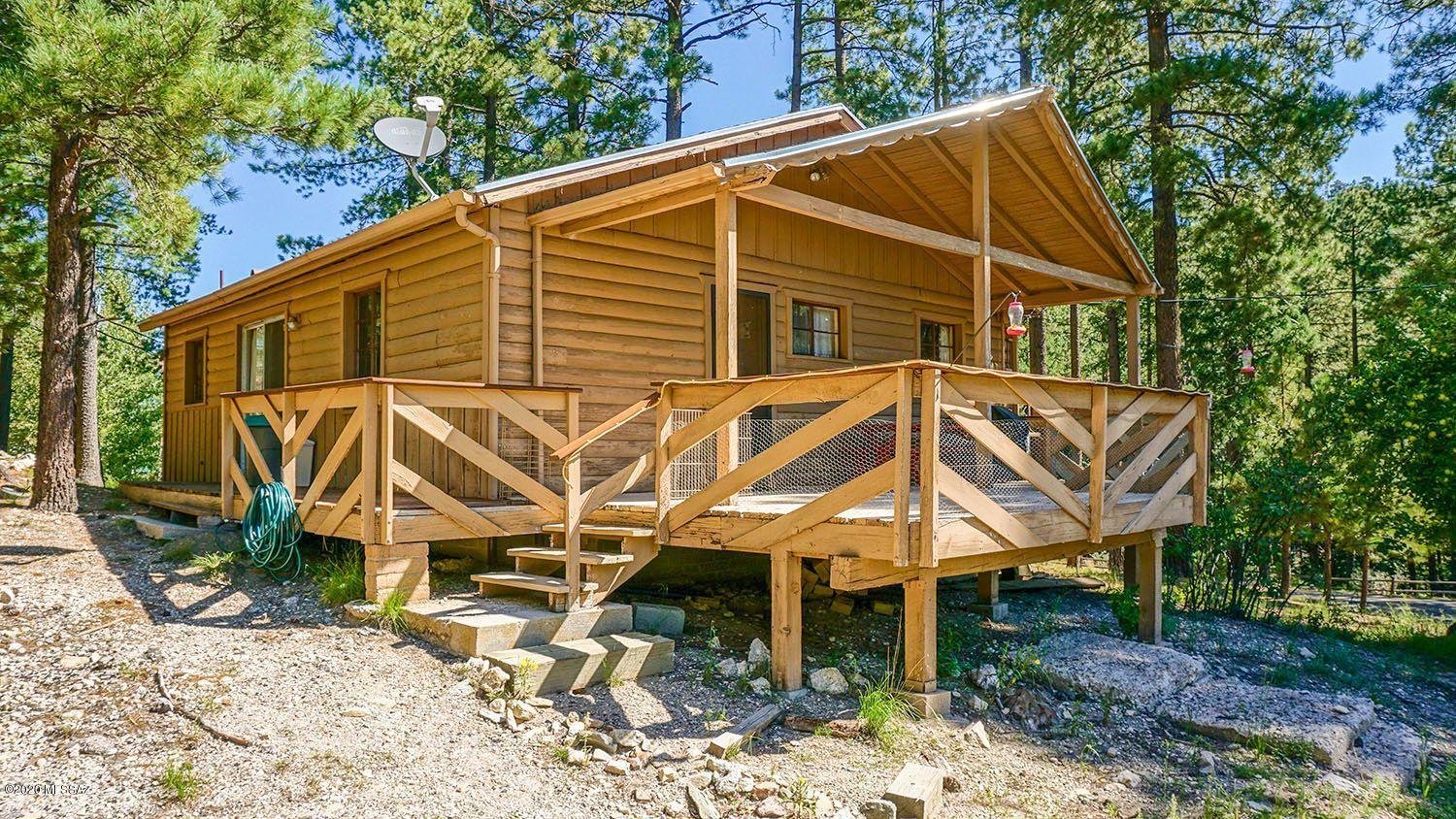 Cute cabin on a prime corner lot in Summerhaven! Very short walk to General Store and restaurants. Privacy on 3 sides, with a front-row view of the UArizona Park Preserve. 2 beds, 1 bath, living area has a large, wood-burning fireplace, wood stove, and knotty pine walls. Grab an apple from the tree off the front porch, sit back, and enjoy bird-watching by day, and star-gazing by night. Cabin gets frequent visits from wild turkeys and deer. Street is plowed in winter for year-round access. A great getaway in one of the best locations in all of Summerhaven!
(Cabin being sold 'as-is.' Some furnishings available on separate bill of sale)