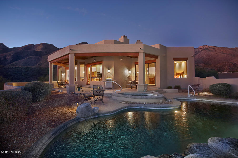 Stunning Southwest Contemporary built by Paul Rondelli on a high lot in coveted Alta Vista Estates. This meticulously maintained home has both mountain & city views. A marvelous floor plan includes both formal dining and living rooms. The granite kitchen opens to family room w/fireplace, extensive covered patio w/plank & beamed ceilings with amazing views, yet is very private from the lush surrounding desert landscape. Home has no interior steps, self-cleaning pebble tec pool, spa, a waterfall & kiva fireplace w/bancos.  Master suite features fireplace, spa tub, dual vanities, views! This 4BR(den could be 4th BR) 3BA has lovely tasteful touches and is a great foothills find at this price.