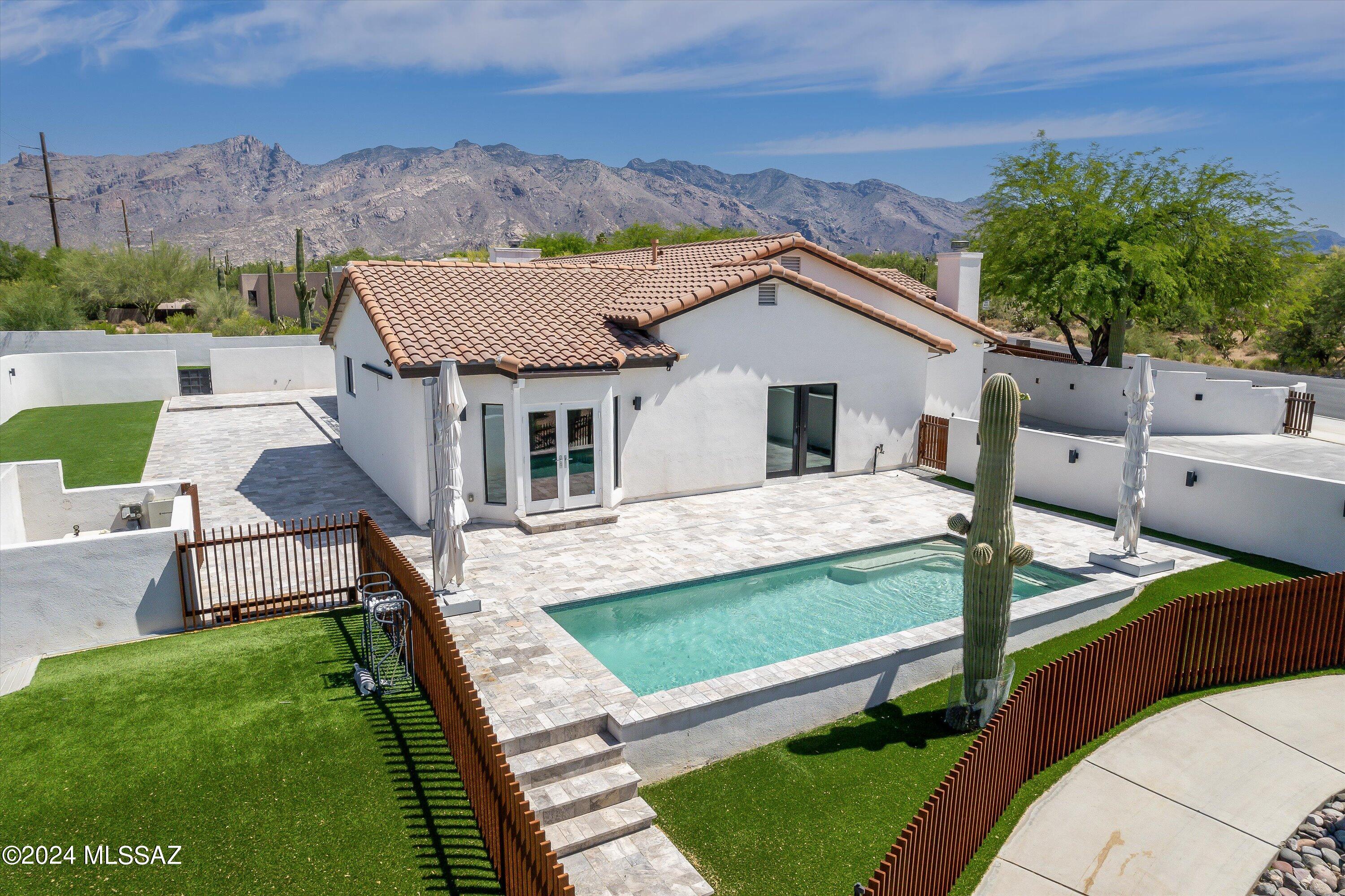 Luxury living in the heart of the Catalina Foothills on .88 acres, fully fenced with a gated entry, city, mountain views, and District 16 schools. This private compound was re-designed for ultimate relaxation and enjoyment. The Great room & dining area are the heart of the home. The additional living space can be a 4th bedroom, game room, or a second home office.  The highlights of the Chef's kitchen are a commercial grade six-burner gas cooktop with pot-filler, double ovens, an island with a built-in refrigerator, freezer, and beverage refrigerator.  The Butler's pantry has a full-size side-by-side refrigerator, and freezer plus prep sink and built-in cabinetry.  The two sets of stackable sliding doors expand your living and entertaining space. Air-conditioned 3-car garage+workout space. The outdoor kitchen, fire feature with seating for ten, and irrigated upgraded turf helps keep the surface clean and cool.   The resort style pool, walking path through the desert garden, and your own private golf hole make this property stand out from all the others. Don't miss all the additional parking on the paved driveway. No HOA so bring all your toys! Updated and move-in ready. A must see Foothills property. See document section for Floor Plan & Special Features List.