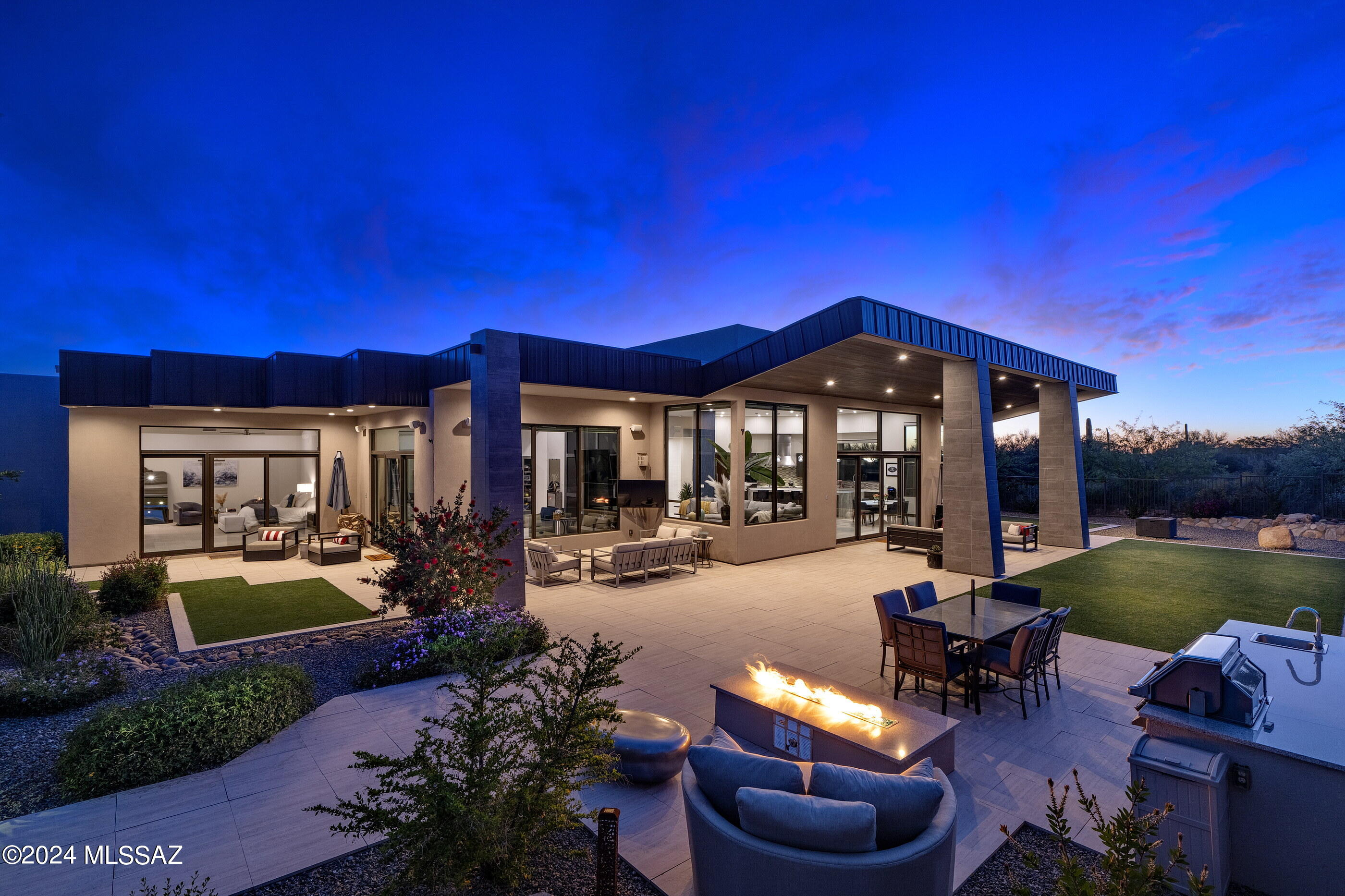 Unfolding across the 1.48 acre custom homesite and situated behind the secondary gates of the exclusive Reserve at Pima Canyon enclave, this incomparable residence demands privacy while preserving views that open out to far reaching vistas of the adjacent Catalina Mountains. The home's architectural identity is defined by the striking anodized steel roof cladding, juxtaposed against Dryvit plastered walls, presenting a visual and compelling composition of both horizontal and vertical form. Spanning the 5,378 square foot split bedroom floor plan, the home's layout flows continuously with the topography, while the backyard adapts to the gentle cant of the nearby hillside. Volumes of shifting scale, with walls of windows expose resplendent natural light, while simultaneously maximizing the Catalina Mountain views at every turn.

Upon entry, one is greeted by a foyer with soaring ceiling heights, establishing the main connection point of the home, which opens onto the great room, consisting of a living room, dining, and a chef's kitchen. The kitchen, acting as a center point of the home, is not solely a culinary workspace, but invites its users to engage in the rituals of daily life. Tones and textures, juxtaposed against natural stone and custom millwork create an intrinsic beauty found in the authenticity of the materials. At the heart of this epicurean experience is a suite of professional Wolf and SubZero appliances that merge functionality with a design-forward sensibility, elevating the art of the culinary experience.

Accommodations are split across the primary level, with four ensuite bedrooms, a dedicated office/media room, and guest powder room. The primary suite is concealed on the East wing of the property, complementing the home's design ethos, where style and functionality coalesce. Every detail has been carefully considered, from the proportions, to the choice of materials, with millwork that seamlessly integrates within the space, while maintaining an aesthetic that resonates within the broader design narrative.

The property accentuates the indoor and outdoor lifestyle, having been masterfully designed for entertaining, with layers of elevated patios creating the framework for the pool and spa acting as the centerpiece of the backyard experience. The scale and grounds have the feeling of a boutique resort, with pavers that connect the various social spaces, which include a Napoleon barbeque station, gas fire pit, and large covered verandas perfect for al fresco dining.

Ultra-exclusivity meets convenient proximity to all of life's necessities. From this central Foothills location, one is just moments away from hiking and biking trails, La Paloma Country Club, La Encantada, and Casas Adobes shopping and restaurants just to name a few.