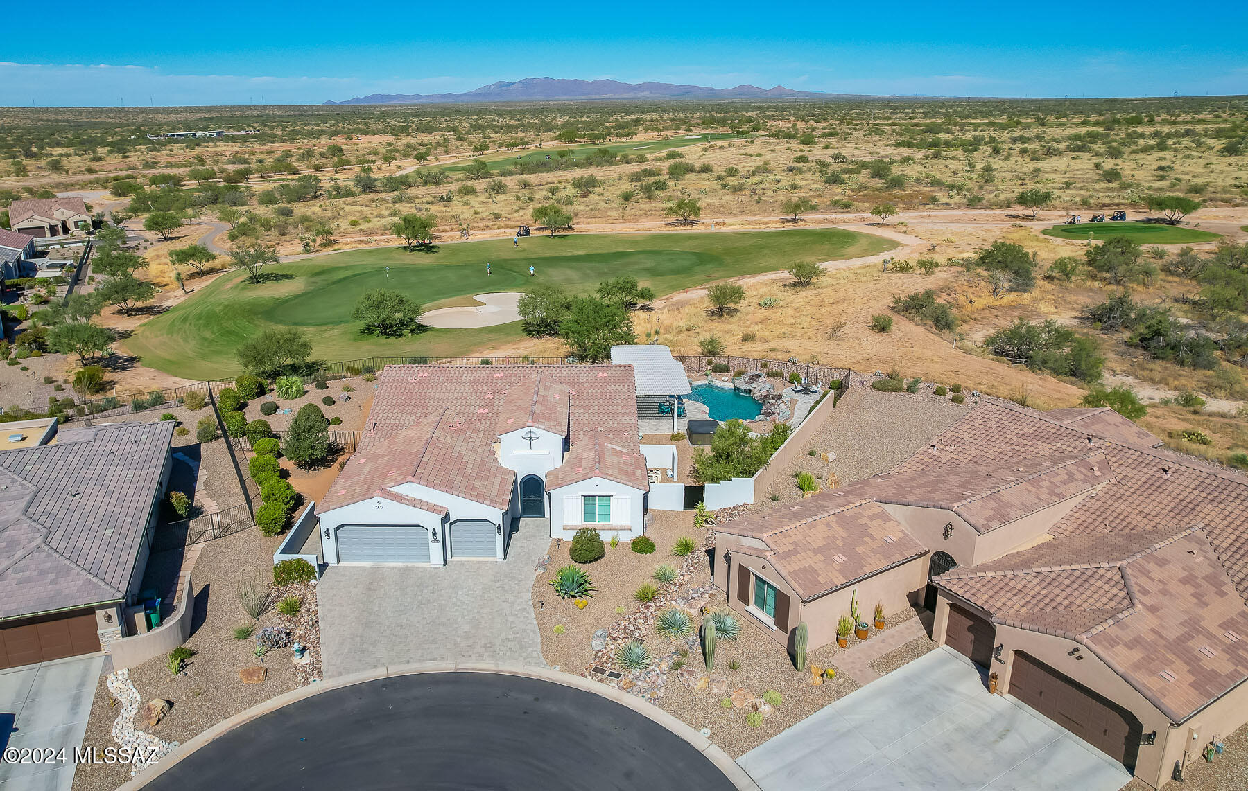 Exceptional, newer 3BD/2.5BA (2,798 sq ft) home on a premium .32 acre cul-de-sac lot on golf course showcases a Contemporary flair on a grand scale. This spectacular home boasts overheight ceilings and doors, diagonal set plank tile in main living areas, dual en-suite bedrooms, quartz countertops and matching cabinetry throughout, plus a solar heated pool and Catalina mountain views. Welcoming paver drive and walkway flow to a gated porch with decorative wrought iron door. Inviting foyer with recessed ceiling flows to an expansive gathering room ideal for entertaining family and friends. This grand room is highlighted by impressive floor-to-ceiling view windows with remote sunshades, recessed lighting and ceiling speakers, plus an elongated art/media wall complete with sound system, mounted television and plenty of undercabinet storage. Open dining area adjoins a gourmet kitchen hosting curved center island with bar, GE slate gray appliance suite including in-wall ovens and 5-burner gas cooktop, cabinet pull-outs and soft close drawers, plus large walk-in pantry. Elegant Owner's suite hosts a luxury bath with dual sink vanity, curbless walk- or roll-in shower plus extended walk-in closet. Second en-suite bedroom offers shower/tub and walk-in closet. Third bedroom with French door entry and dual closets could also serve as an office. Additional amenities include plush carpeted bedrooms, laundry room with 2-door utility closet, powder room, rear patio speakers, four outdoor water spigots and gas BBQ stub. The 3-car garage with 4' front extension houses a water softener and overhead storage racks. Additional 5' driveway extension and 2' extension on Owner's suite and closet plus Bedroom 2 suite. Tranquil outdoor oasis boasts a Travertine patio with shade pergola, extended Travertine pool surround and walkway to corner patio overlooking golf course, solar or gas heated pool with sun ledge, grotto, expansive rock waterfall and "resistant jets" for aqua therapy and fitness, a hot tub, gas fire pit, wrought iron view fence plus meticulous landscaping and hardscape. Saddlebrooke Ranch active adult community offers golf, indoor/outdoor pools, fitness center, tennis/pickleball and so much more. Perfect for the most discerning buyer!