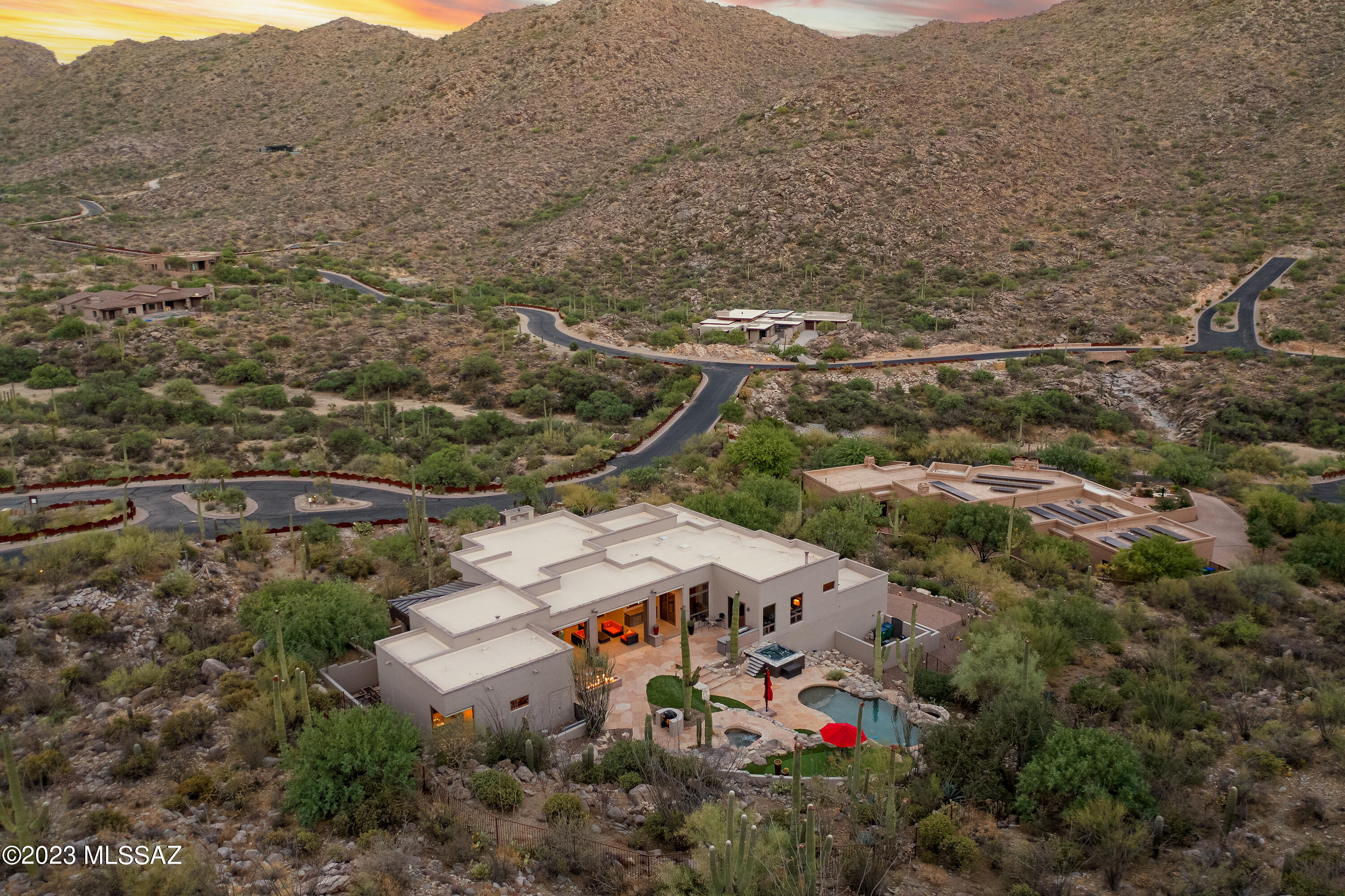 Located in the guard gated community of Canyon Pass at Dove Mountain, you will be captivated by the mountain views as you make your way through the canyon to this impressive 4,810 SqFt contemporary style home that sits on 2.09 acres in the hillside of the Tortolita Mountains. Located in the guard gated community of Canyon Pass at Dove Mountain, you will be captivated by the mountain views as you make your way through the canyon to this impressive 4,810 SqFt contemporary style home that sits on 2.09 acres in the hillside of the Tortolita Mountains. Upon arrival, take in the serene setting that surrounds you, as the breathtaking panoramic views of the Tortolita mountains, valleys, and vast natural desert landscape provide plenty of privacy and the perfect backdrop for Arizona's spectacular sunrises and sunsets. The dramatic arched iron double entry doors welcome you to an open concept plan that is complimented by sharp edges, soaring ceilings, walls of windows, and natural stone and wood flooring.
Ideal for entertaining, the main level boasts an exquisite formal dining room, a grand great room with remarkable views, floor- ceiling stacked stone gas fireplace, built in entertainment center, and access to your backyard oasis. The open kitchen with dining nook is a chef's delight, as it features Wolf and Sub-Zero appliances, island with gas cook top, gas oven, warming drawer, and bar seating.

This luxury home also features a split-bedroom floor plan with dual master suites, and a laundry room and pantry that are sure to please. The primary suite is spacious and features a gas fireplace, oversized widows that capture the sensational views, and access to the rear and side patios. The ensuite bath is sure to impress due to the secluded rock waterfall that flows right outside, providing the perfect setting while relaxing in the jacuzzi. Also featured is 2 large walk in closets, dual vanity, and walk in shower. Located adjacent to the primary suite is the office/den/3rd bedroom with custom built-in cabinetry and amazing views. The hall bath is conveniently located just outside the door and features built-in shelves and a walk-in shower. The secondary suite is sizable with a large walk in closet, back patio access, fabulous views, and an ensuite bath with dual vanity and walk-in shower.

The lower level, with stairway and elevator access, boasts a home theater with built-in cabinetry and wet bar, powder room, wine room that houses over 1,000 bottles of wine, and a bonus room that is currently being utilized as a music room, but would make for the perfect home gym, complete with floor-ceiling mirrors. Also located off of the lower level is the 3-car garage with built-in storage and additional storage room.

Whether you are entertaining or relaxing you will thoroughly enjoy having your own private backyard oasis that is nestled in a hillside, offering complete privacy, as it boasts an expansive covered patio with sunshades, large outdoor kitchen with fridge, linear gas fire pit, grill area, saltwater lagoon style pool and spa, hot tub, outdoor shower, putting green, and a captivating rock waterfall that flows amongst it all.

When privacy is important and serenity is key, there is truly no better place to be!