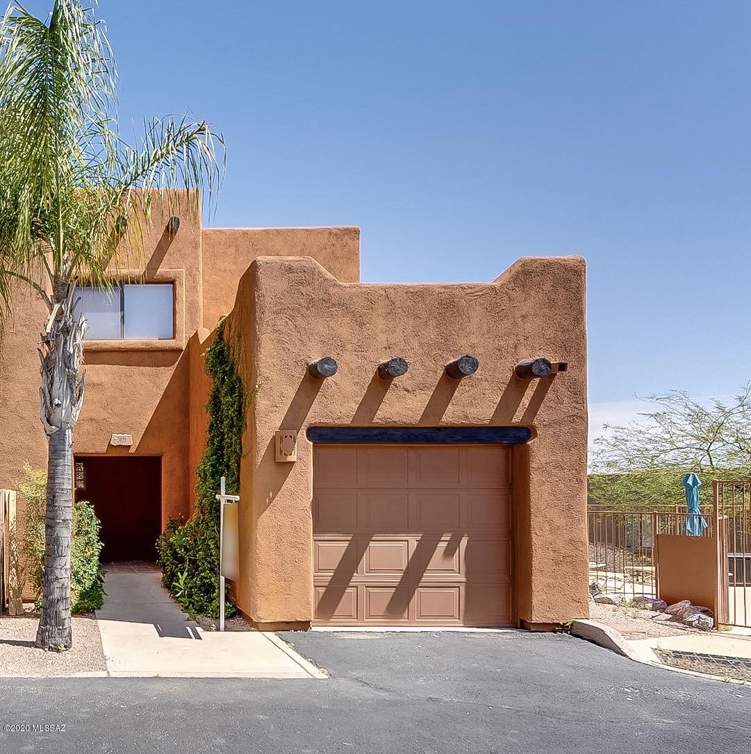 Wonderful Santa Fe style condo that lives like a Townhome!  Located across from Tucson National.  The location of the property is situated high and adjacent to the pool making this ground floor condo very desirable.  Gorgeous Mountain views from the open kitchen/living area.  Updated appliances and flooring.  Split bedroom plan, fireplace, one car garage, and outside storage room.  This will not last!!!!!!!