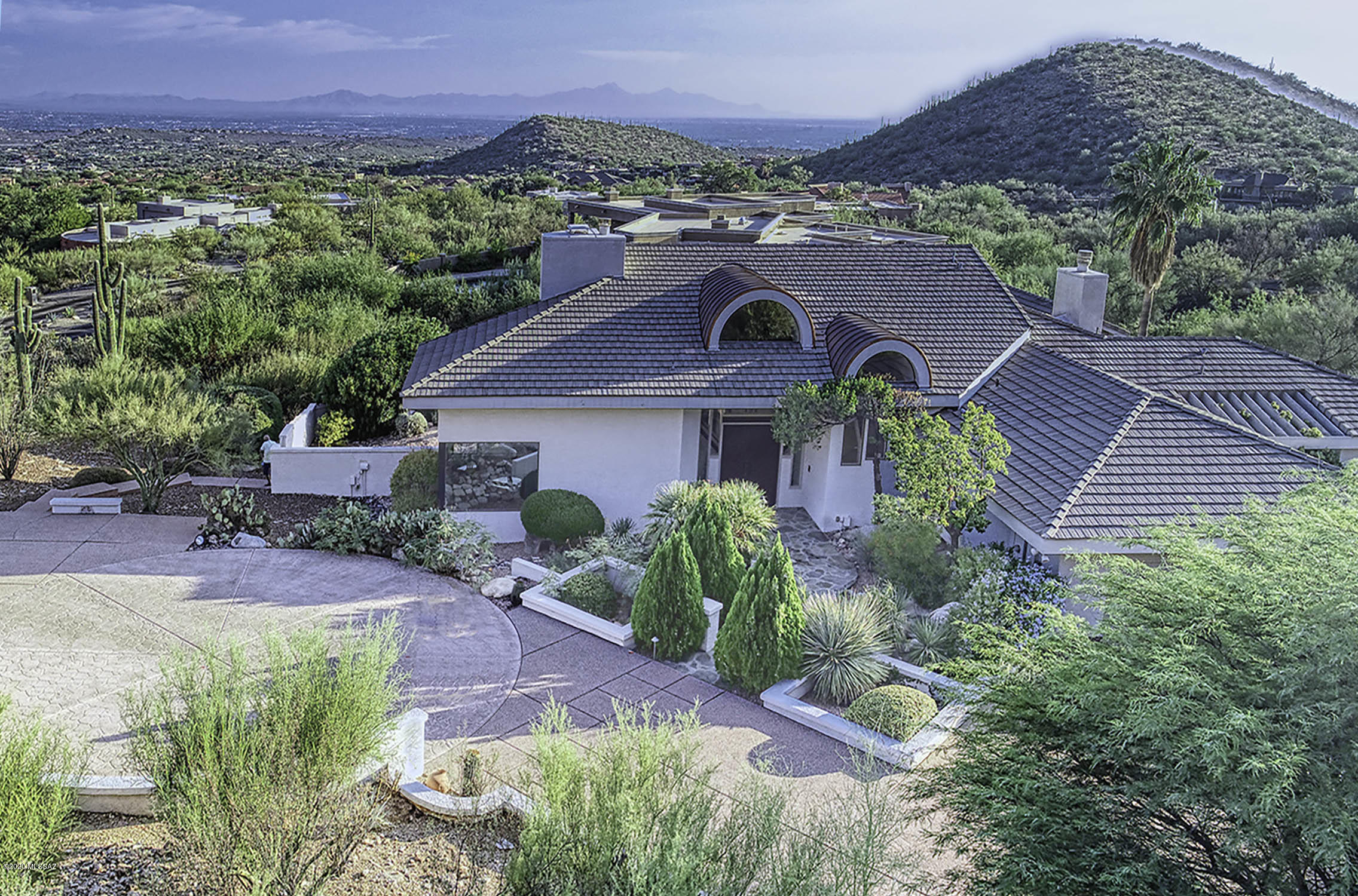 Premium Finisterra location nestled high against Catalina Mountains  with dramatic city light views. Striking Southwest Contemporary design surrounded by multi-million-dollar homes. Home is immaculate and ready for updates. Perfect Canvas for exciting refresh includes 2 living areas, 4 bedrooms, 3 baths, 5 fireplaces, high ceilings, tile roof, over sized windows, plus large owner's suite on 2nd floor with oak wood flooring. Enjoy Outdoor Retreat with large pool and spa, Ramada with BBQ, plus firepit and outdoor fireplace. Beautifully landscaped including entry courtyard with bridge and water feature.  4 car garage and long driveway for you and guests. All this in prestigious guard gated Finisterra in a location that cannot be duplicated. 2 car detached garage could be converted to studio