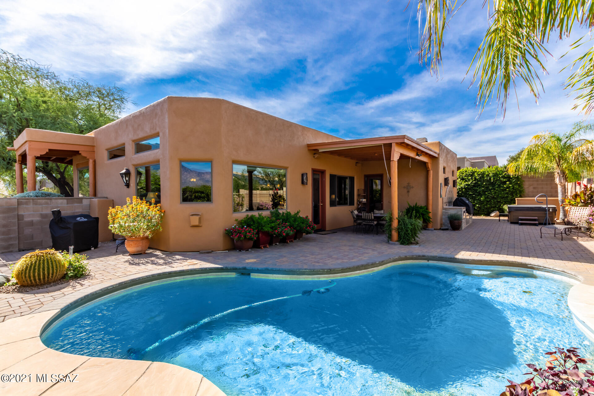 Beautiful semi-custom Santa Fe home with amazing mountain views in desirable Catalina Shadows neighborhood. 3BD/2BA, gourmet kitchen with designer tile backsplash, granite counter tops, upgraded paint, tile and stainless steel appliances. Cozy fireplace and amazing views out the large picture windows in great room and formal dining.  Upgraded mstr bath, tile, cabinets, dlb sink, and granite counter tops.  Guest bedroom/office built-in desk & murphy bed. Epoxy 3 car garage, extended height/length, workshop, cabinets and central vac. Beautiful backyard, ext'd covered patio, solar heated pebble tec pool, built in BBQ, hot tub and gorgeous landscaping. Perfect location close to parks, Oro Valley Marketplace, hospital, shopping & dining. Must see has it all!