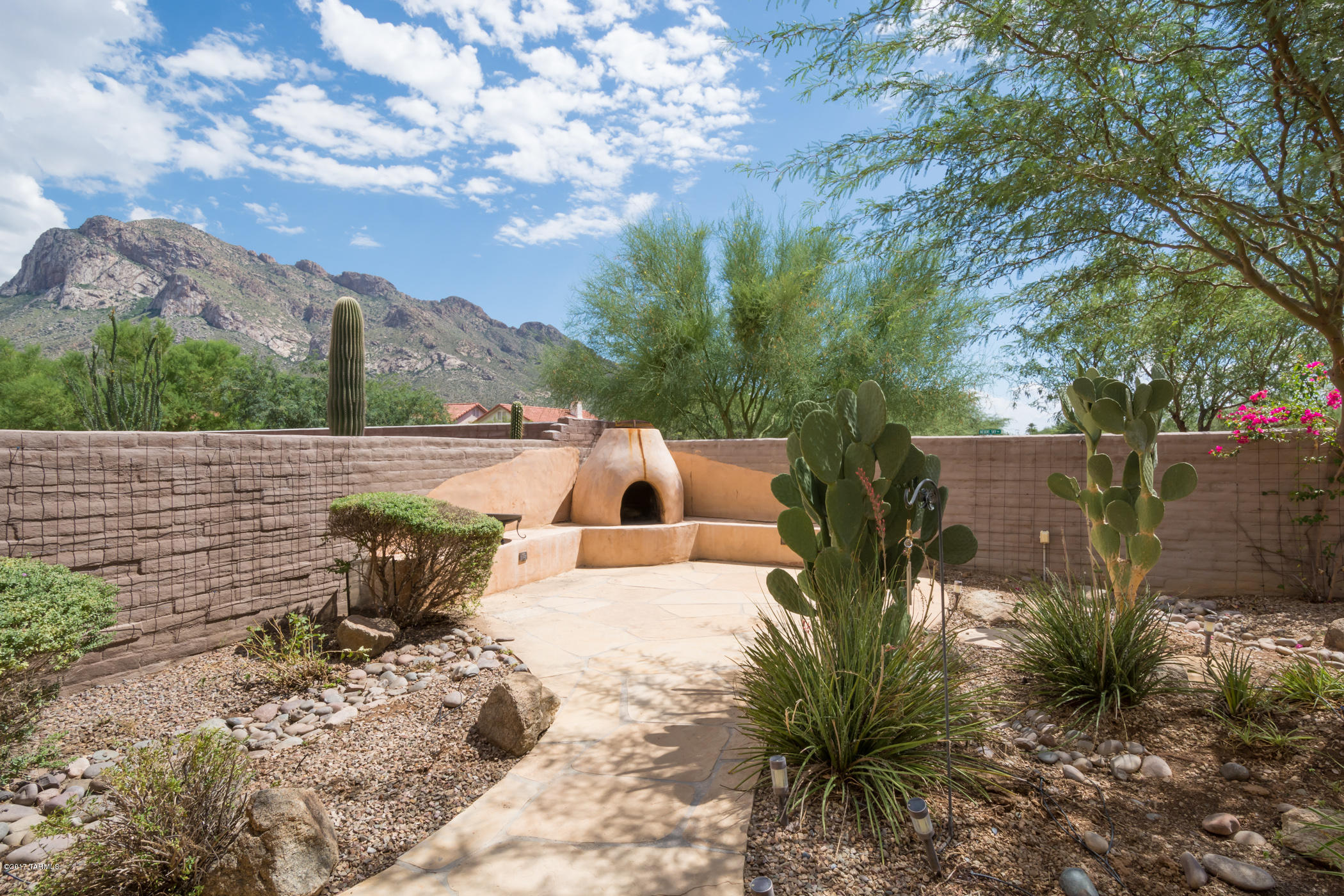 Wonderful small enclave of luxury homes, gated community nearby the Catalinas. Great room design, spacious kitchen opens to Great room with 3BR/2BA, 2 car-garage w/1639sf to enjoy the Tucson lifestyle. Perfect for year-round or second home for seasonal-owner. Great views, and backyard is an oasis with mature desert plants and large shade trees. Gorgeous outdoor fireplace, banco seating for extra guests, easy to relax or dine Al fresco soaking up the mountain views. Gated access- Call for information or to schedule a personal showing.