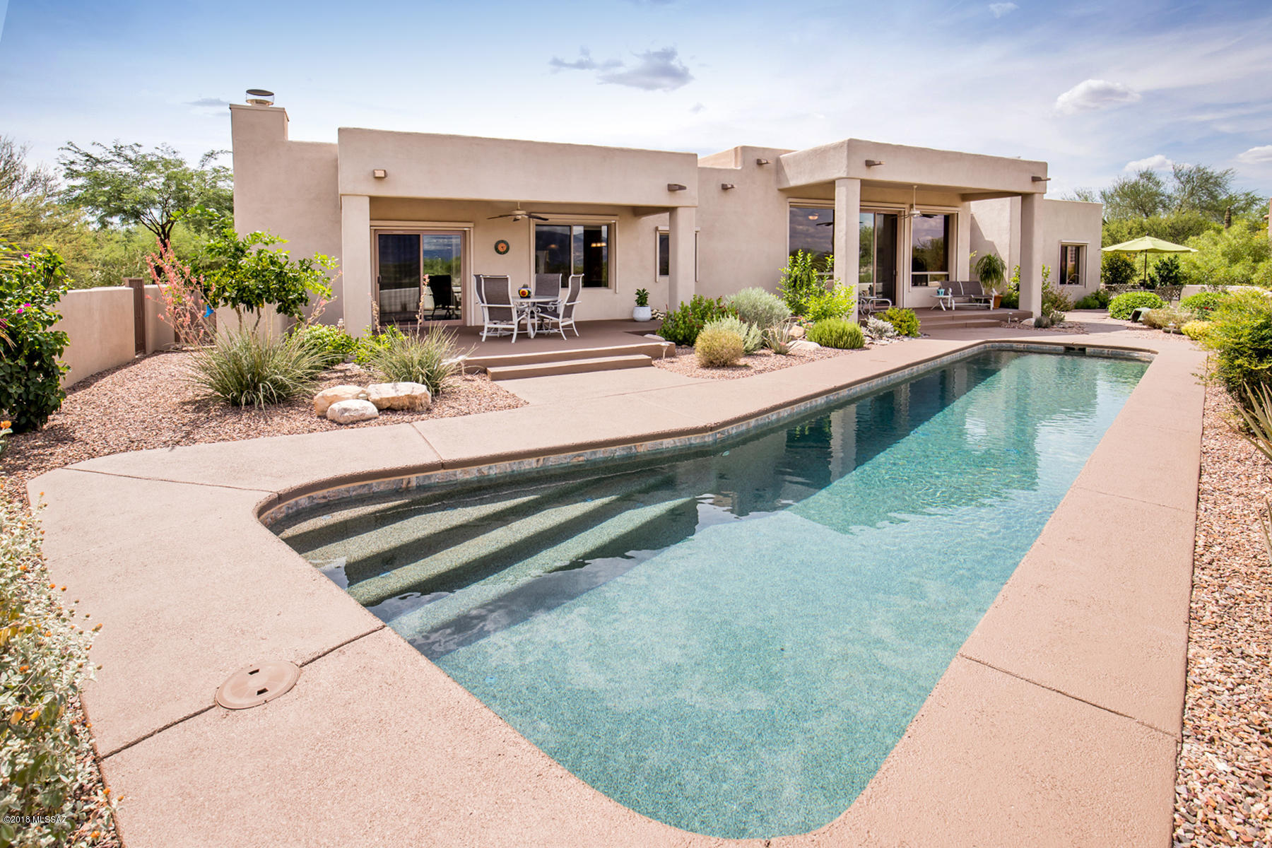 Wonderful contemporary masonry custom home located in small gated community of Estates at High Mesa  in Oro Valley's Rancho Vistoso neighborhood. Located on private one acre cul de sac lot with stunning Catalina Mountain views and bordering natural desert. Four bedrooms, three full bath, tasteful remodel of kitchen and bathrooms, new tile flooring throughout. Fireplace in family room and master suite, wet bar and entertainment patio with solar heated pool. 
True Arizona living at its best!