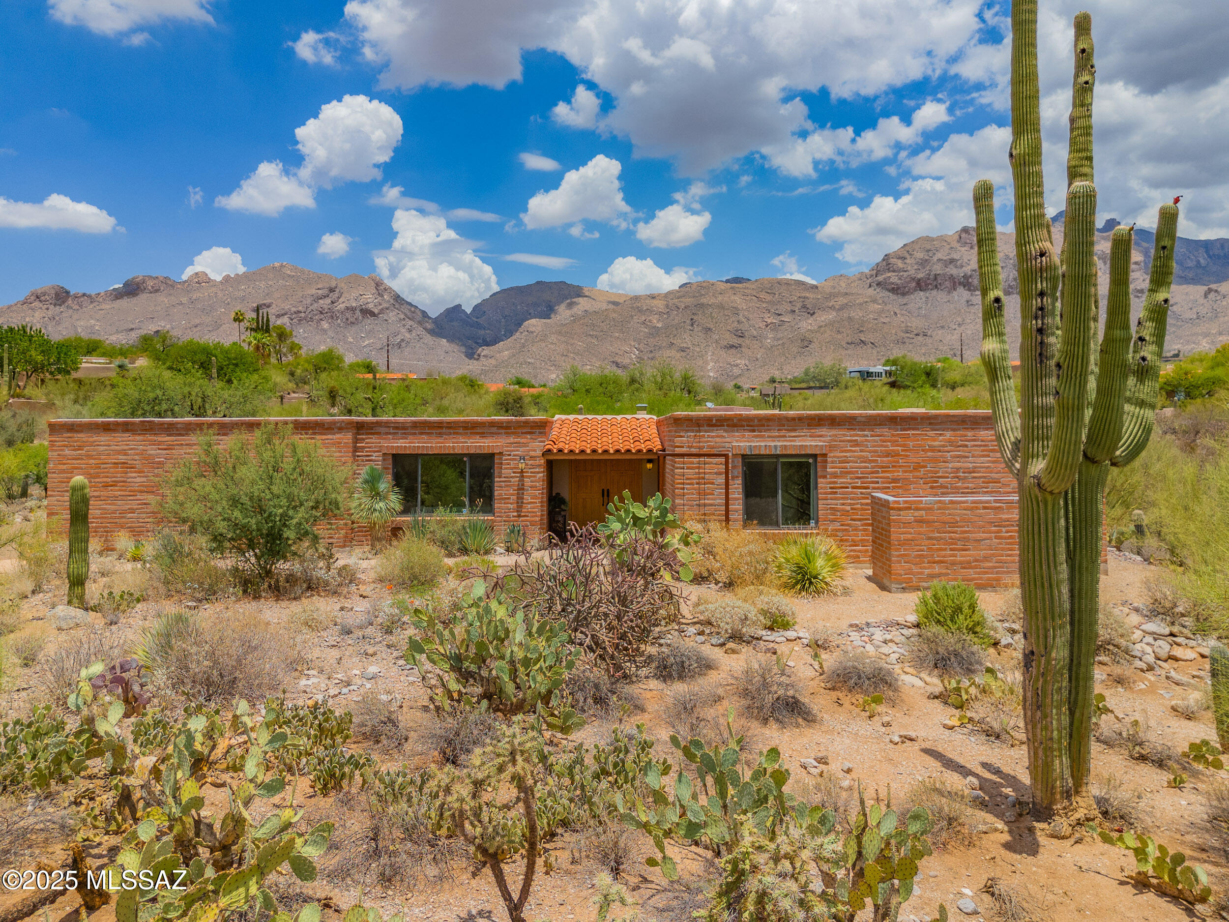 This classic 4-bedroom 2.5 bath updated adobe is located in an established Catalina Foothills Estates neighborhood on a private peaceful 1 + acre lot. Enjoy sweeping Catalina Mountain and exquisite desert views from the pool, hot tub, covered patios and most interior rooms. Property is home to more than 20 saguaros, lush natural desert plantings and wildlife. 
The chef's kitchen is complete with high-end stainless steel appliances including commercial Blue Star 6-burner gas range and Viking refrigerator, center island with breakfast bar, tasteful slab granite counters and cherry cabinets with soft-close doors and drawers. Family room includes plank exposed wood ceiling and custom designed gas fireplace. Huge laundry room has pantry, granite countertops and cherry cabinets.