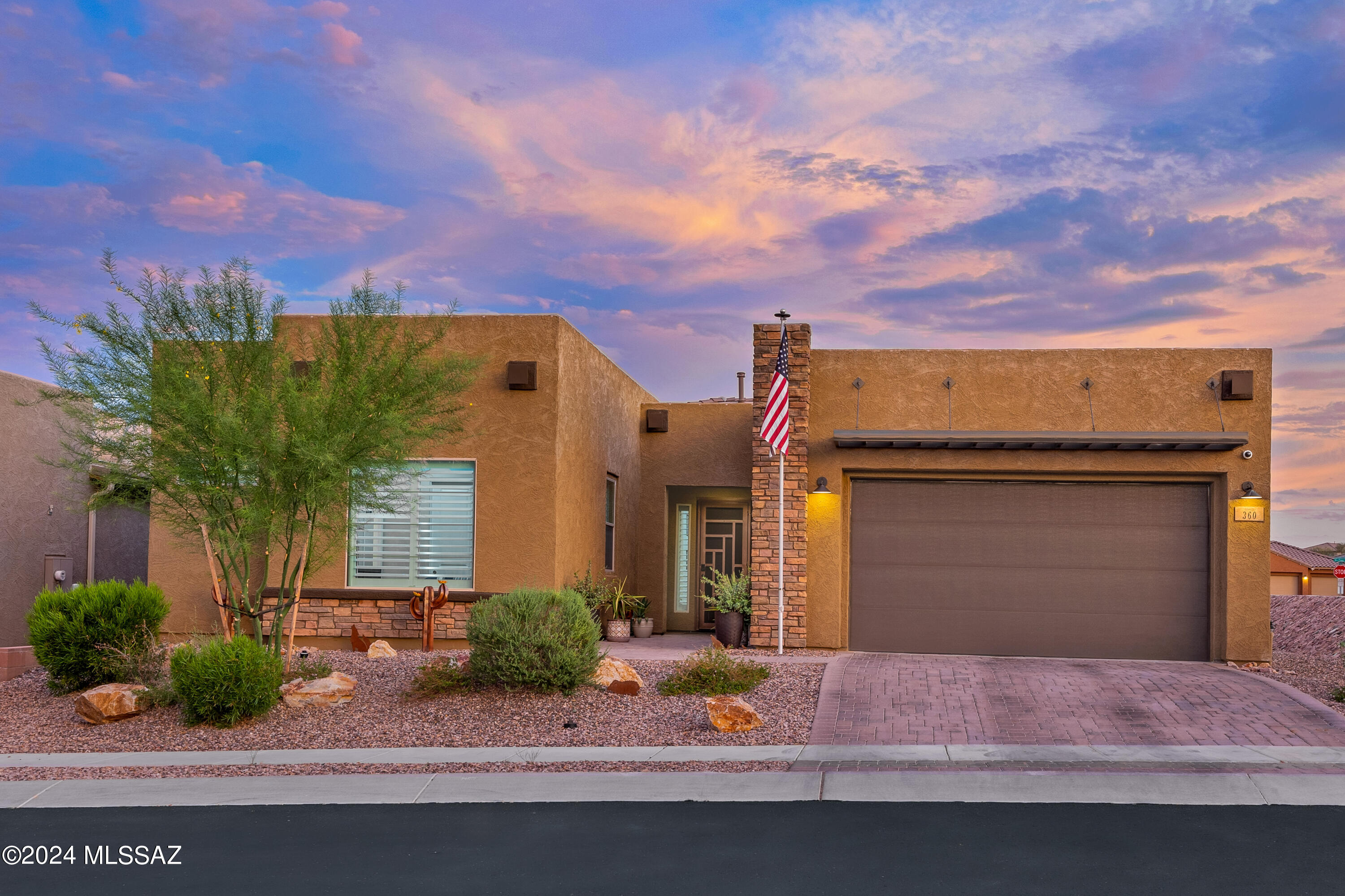 Paradise found in upscale gated Alterra. Ready for your most discerning buyers, this masterpiece features corner privacy lot with spectacular mountain views from the southeast-facing patio, a gourmet chef's kitchen with stainless appliances and an executive kitchen island with Minka Air custom light fixtures and LED canned lighting.   This highly sought ''Patina'' floor plan Smart home offers 3 bedrooms PLUS den or 4 bedrooms.  The Living room boasts vaulted and coffered ceilings and a 72'' electric fireplace on a large entertainment wall.  Step outside to your desert oasis through the cascading sliding glass wall for that indoor/outdoor connection to a large covered patio.
Owner's Suite has extended wall and bay windows capturing the mountain views, an oversize walk in shower, soaking tub, dual vanities, custom closet organization,  sliding barn door and French door to patio secured with an iron security door. Highly upgraded home with custom cabinetry, wood-like tile flooring, granite countertops, and high-grade carpet and padding in bedrooms. Every room has canned LED lighting, remote-controlled ceiling fans, and established AV ports for ease of wired and wireless connectivity.  The smart home hub provides connectivity indoors and outdoors and comes complete with a WiFi extender, security cameras, a home security system, smart door lock and doorbell, three digital thermostats, and a ceiling sound system for the living room and patio.  The home also features real wooden plantation shutters, a water softener loop, wrought iron security doors, and an extended epoxied 3-car tandem garage complete with custom cabinets, shelving, and storage organization. Also, it features a 50 amp electrical outlet for a golf cart or RV and can be converted to an EV charger.  Step outside to experience outdoor living at its finest with an entertainer's backyard oasis, with a large heated automated pool with waterfall, spacious relaxing spa, gas firepit, custom Ramada, and large built-in BBQ island; all on travertine pavers and artificial turf!  This home would not be complete without rooftop solar boasting a 125% generating capacity of 15.2 kwh to offset the high summer electricity consumption. Home is situated in an area of very low noise and light pollution.