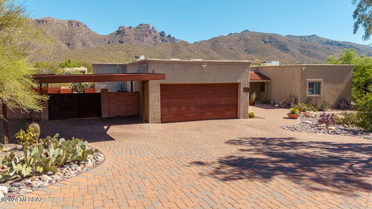 Breathtaking views of the mountains and easy access to hiking trails, this home is a nature lover's dream come true.  The gourmet kitchen is a chef's delight, with quartz countertops, birch cabinets, gas cooktop and stainless steel appliances.  Escape to your own private oasis in the backyard, where paradise awaits. The custom-made outdoor kitchen and counter seating area overlooks the sparkling pool and rock waterfall. Relax under the covered patio or soak up the sun on the flagstone terrace—every corner of this backyard has been meticulously designed for enjoyment. This home offers plenty of space for family and guests with four bedrooms and three bathrooms, including a luxurious primary suite with a spa-like ensuite bathroom & a custom walk-in closet with frosted sliding glass doors. With a two-car garage, two-car carport, and RV pad, there's ample parking for all your vehicles and toys. Best of all, there are no HOA fees to worry about, giving you the freedom to personalize your property to suit your lifestyle.  Conveniently located within walking distance to hiking trails and just minutes from shopping, dining, and entertainment options, this home offers the perfect balance of tranquility and convenience. With its unbeatable views, luxurious amenities, and endless outdoor adventures, this is suburban living at its finest.