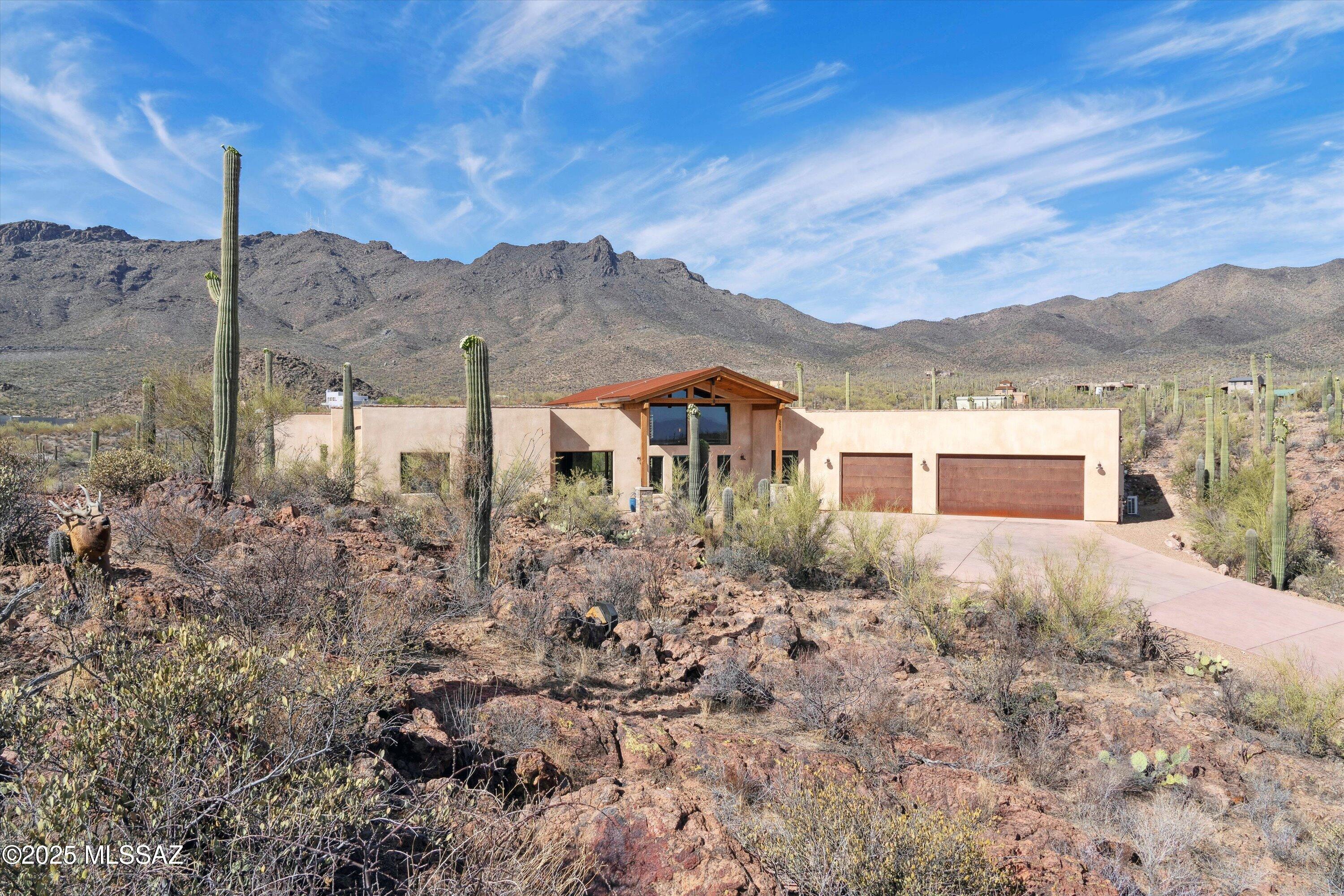 This exquisite well thought out design offers an element of creativity and craftsmanship at every turn. The main living area is an open flowing environment with soaring ceilings that represent engineered timber trusses with tongue and groove from end to end in the great room. The massive windows and collapsible panoramic doors capture the dramatic and unobstructed views of the Tucson Mountains which are perfectly situated in the heart and saddle of the canyon. The interior continues to unfold with an abundance of natural light as you make your way into the gourmet kitchen with top-of-the line cabinetry designed by Canyon Cabinetry, professional grade SS appliances, sub zero fridge, granite countertops and colored concrete floors throughout. The primary suite is ample, you will love the openness as you pass into the primary bathroom to explore the remarkable tile work, double vanities, a soaking tub to pause and relax in and your own personal sauna. As you continue to explore all the facets of this amazing home your expectations will continue to be met, all of the bedrooms are appropriately sized and this split floor plan offers a private and spacious guest room with bathroom.

As you transition to explore the exterior your enjoyment will continue, as nature itself is captured and the backyard design becomes the center of entertainment with its large sparkling saltwater pool with heater, fire pit (plumbed for gas) and huge covered porch. The water catching system and solar panels show the efficiency, detail and intent that comes with this home.

The large three garage offers a mini split system and additional cooled storage space area, the exterior rough sawn beams and extended colored concrete driveway add to the character of this amazing home.

The majority of the furniture is negotiable to stay and was specifically picked to fit every space in the home.