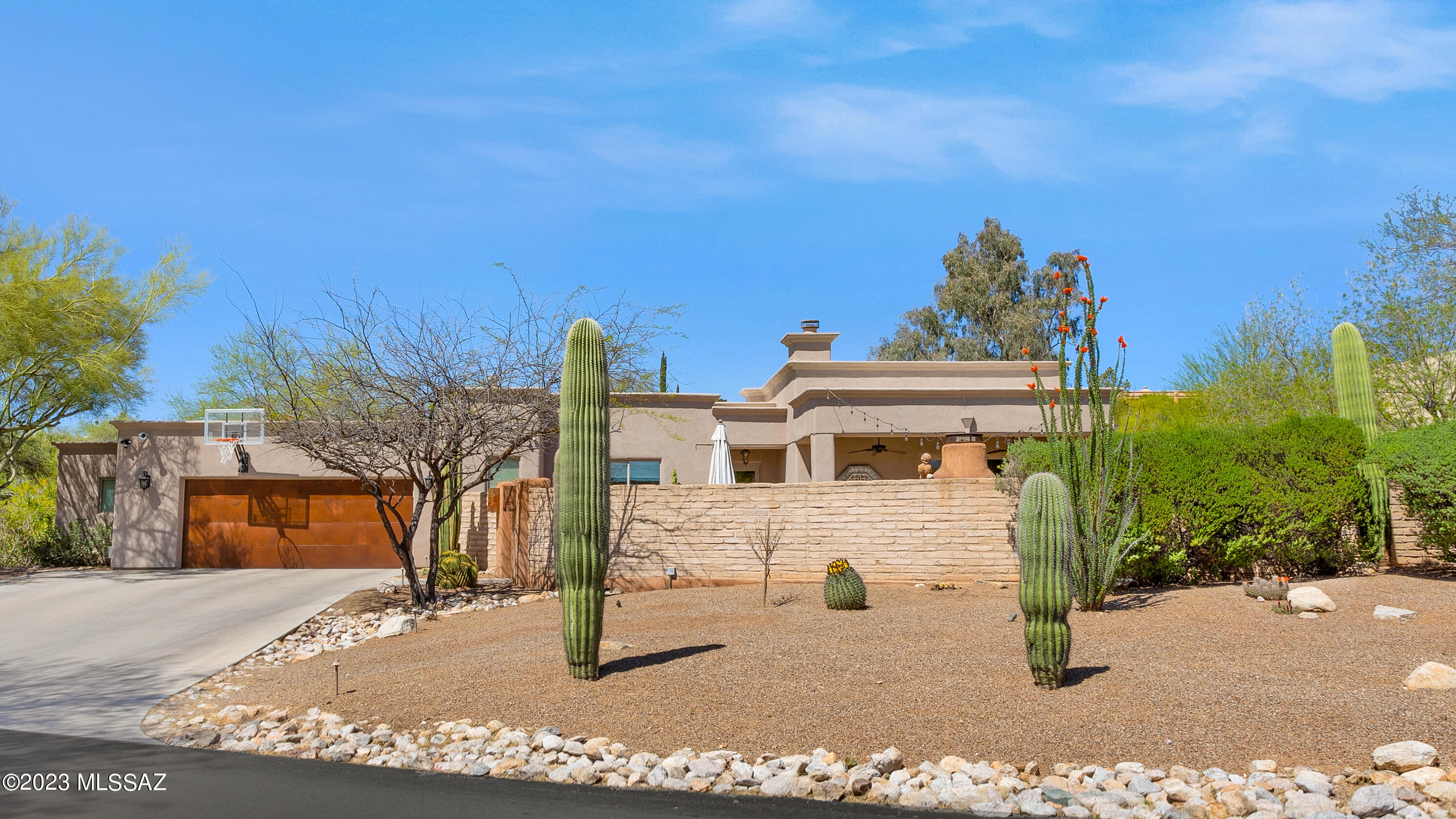 Immaculate contemporary home on a premium (over half-acre), cul-de-sac lot in Catalina Foothills with District 16 schools.  Greeted with mountain views upon entry into the gated courtyard, the home offers multiple outdoor spaces to gather.  It is truly an entertainer's dream. An open split floor plan with separate entry and a 2nd laundry room give this home great multi-gen potential.  High ceilings throughout and gorgeous reclaimed wood flank the ceilings of the Great Room and both patios, adding warmth and texture while enhancing the timeless design of the home. The kitchen boasts granite countertops, newer stainless steel appliances, and a gas stove. 2 fireplaces (1 in formal living room and a 2nd in the courtyard) and a large Primary bdrm that opens to the back patio make it a perfect, private retreat.  The gorgeous primary bath has been recently renovated and the walk-in closet has custom built-ins.  A Den/Office or opt. 5th bedroom (w/closet) is near the primary bdrm and 3 additional bedrooms, 2 more full bathrooms and a beautiful powder bath are on the other side of the home. Multiple patio areas, a built-in BBQ, new turf in the front and back, mister system, great outdoor lighting, and automatic irrigation for desert landscape make for easy entertaining and upkeep. Gorgeous wrought-iron, extended coyote fencing was added to the backyard to keep pets and children safe. An oversized garage w/a huge separate storage area or workshop provides plenty of room for storage. With Central Vac, Water Softener System, a meticulously cared for roof and a new A/C unit in 2020, this custom home will not disappoint. District 16 schools, Close Proximity to La Encantada Mall/ AJ's, near popular golf courses and a great location for the best of Tucson! Don't miss out on this one of a kind home! Schedule your showing today!