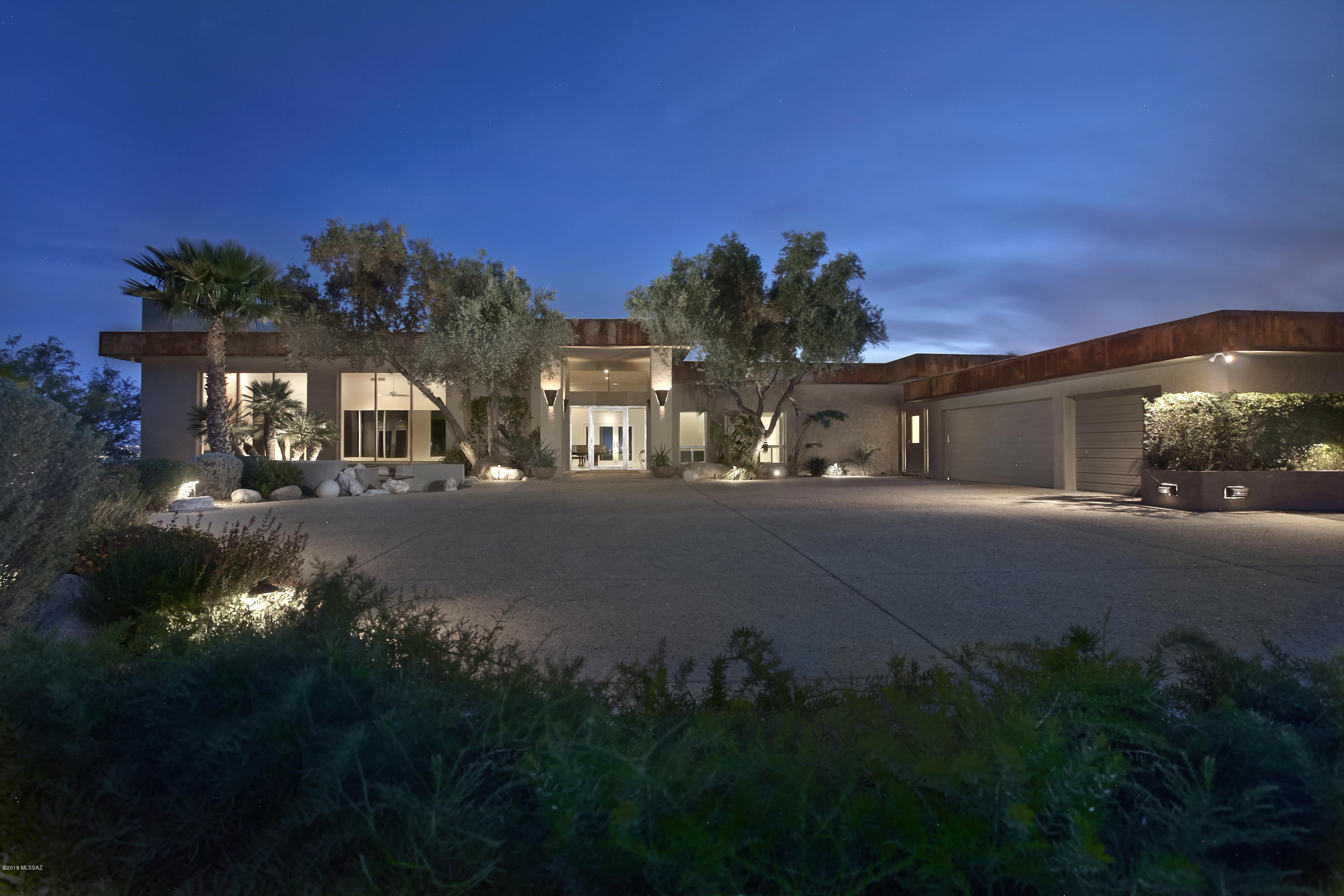 Truly one of the finest contemporary homes in the Foothills on an unrivaled 4.52 acre gated hilltop lot with unmatched Mountain, City & Sunset views! This Minimalistic Desert Chic Contemporary home was built by renowned builder John Wesley Miller & has been recently updated to absolute perfection; uniquely embodying modern luxury & masterful design. Soft grey concrete floors accentuate the clean crisp white walls ideal for an art collection. The versatile floorplan features 5 spacious bdrm suites, 2 w/sitting rooms, den, 5 bathrooms, media rm & art studio. The open kitchen features top of the line appliances, custom cabinets & island. The lush lawn & terraced patios w/pebbletec pool & private cabanas are ideal for outdoor entertaining & provides an unparalleled setting. Private Well/NO HOA