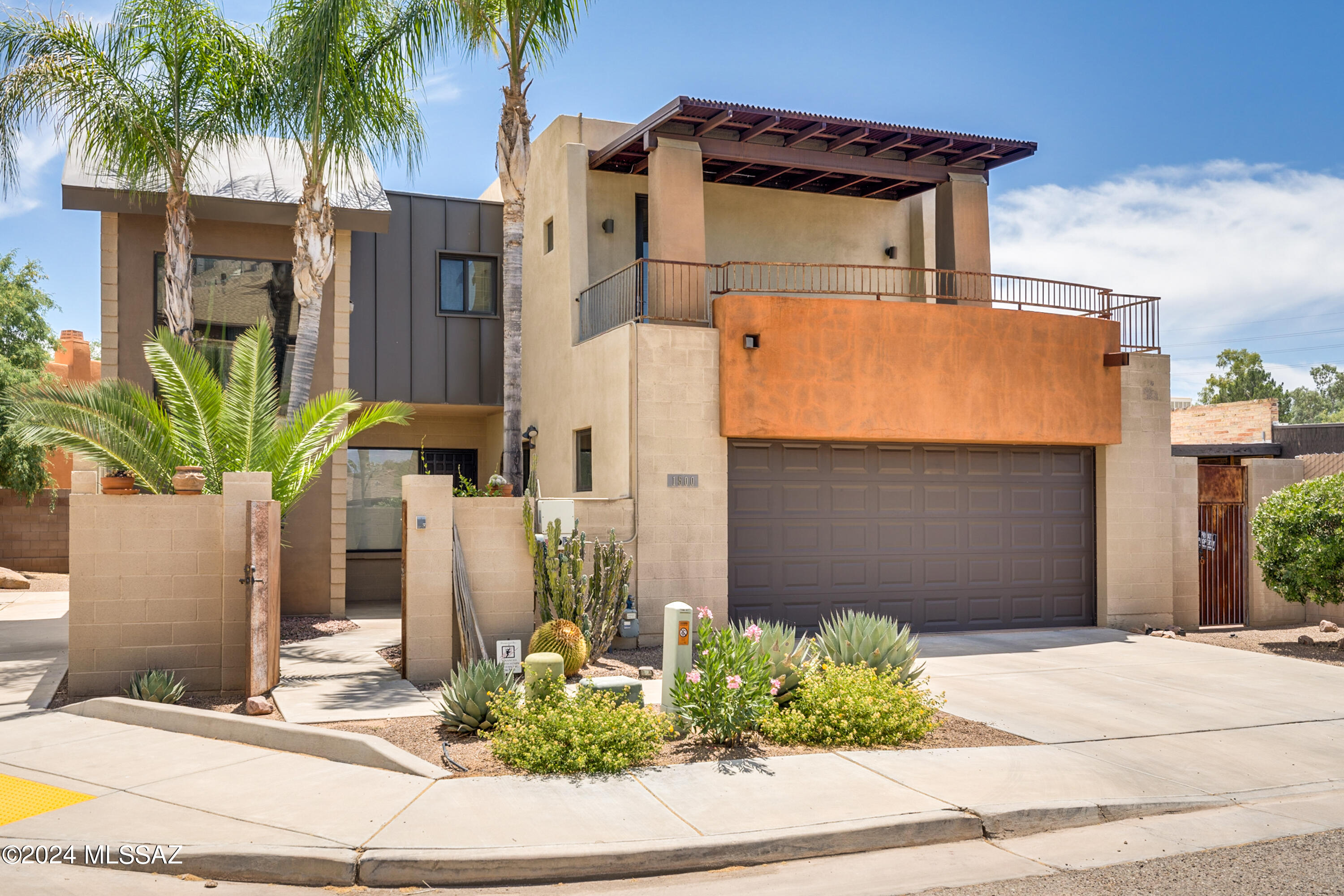 Discover this incredible, one-of-a-kind custom-built home in the heart of Tucson. Nestled at the end of a cul-de-sac, 3 bed/2 bath modern contemporary masterpiece has been immaculately maintained & showcases stylish finishes throughout, including etched polished concrete floors and bamboo flooring on the second floor. Plus enjoy environmental sustainability w/ owned solar panels & NEW HVAC. Step into the inviting enclosed courtyard entry, adorned w/ mature Queen Palms. The spacious great room features high elevated ceilings, fireplace, & ample living/dining areas, the perfect setting for relaxation & entertainment. The gourmet kitchen is a chef's delight, striking high gloss aluminum cobalt blue cabinets, Silestone counters, a tile backsplash, an island with seating, & SS appliances Including a gas range & double wall oven. An alluring staircase leads to the loft, where you can enjoy breathtaking sunset views from the private balcony off the primary suite. The outdoor area is designed for both entertainment & relaxation, with extended paver area, built-in BBQ, & flowerbeds. Additional features include an oversized double garage with ample cabinet storage, owned water softener system. The perfect blend of modern luxury and comfortable living in one of Tucson's most desirable locations. Fantastic central location close to shopping, restaurants, schools, hospitals and more. Don't miss your chance to call this exceptional home your own!