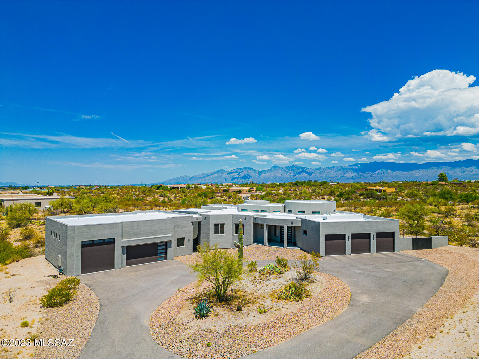Appraisal in hand at $1,260,00.00. Sellers are open to helping buyers with a 2-1 interest rate buydown. One of a kind custom dream home situated on a 2.81 Acre lot minutes from Saguaro National Park with breathtaking panoramic mountain views.  Built in 2019 with 3 bedrooms, 2.5 bathrooms, a large movie room, approximately 200 sq ft of basement, stained concrete floors, custom coffee bar, large steel French door at entrance, high ceilings throughout, and an attached 3 car garage deep enough to fit a full-size truck in either bay. Master bathroom features a deep soaking tub, a separate tile walk-in shower, dual sink vanity with granite counters and a door which leads you to the patio/pool area. The kitchen boasts granite countertops, crown shaker style 42'' upper cabinets, full size side-by-side refrigerator and freezer combo, a Thor 6 burner stove with griddle, tiled backsplash, walk-in pantry, and French doors that lead into the patio/pool area. No expense was spared in creating the perfect backyard to relax, entertain and experience the best sunrise and sunset views. Negative edge Pebble Tec surface, gas heated pool & spa, built-in BBQ grill & bar, large wrap-around covered patio, and over 2,000 Sq Ft of 3-piece Travertine pavers, LED Wi-Fi controlled ambience pool lights. The detached 6-8 car garage with an RV door or a larger-than-life workshop can be converted to living quarters. Pre-plumbed sewer and water connections found on the north facing part of the garage. Recent maintenance includes full exterior paint and roof coating completed in July 2023.