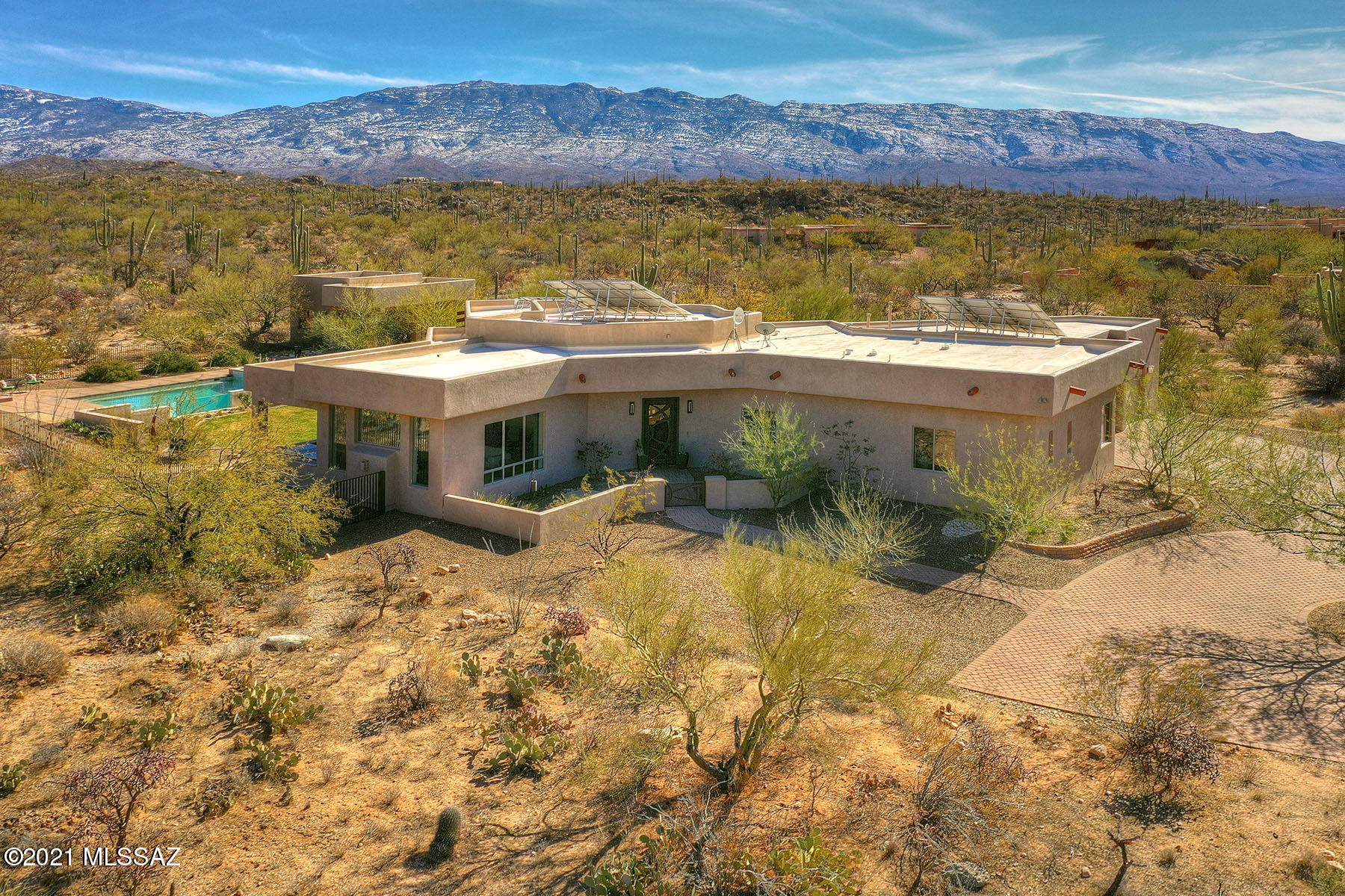 Contemporary masonry home on 4.58 acres in gated NE foothills.  Spectacular mountain views all around.  4 BR/4 bath house plus a 457 sq ft Guest house,  Pool & oversized 3-car garage w/ work room. Everything you would expect including cherry cabinets, gas stove and porcelain tile flooring throughout, solid bamboo flooring in the Guest house, owned solar system and Trane HVAC.  Don't miss glass & metal front door, natural edge Mesquite fireplace mantel or the powder room's fossil sink. Pamper yourself in the free-standing soaking tub.  Step to the backyard to the Zero edge glass-sided Pool, gas firepit, covered patios, grass areas & citrus trees. Guest house has kitchenette full bathroom plus an outdoor shower. Up to the rooftop deck for panoramic views. Make this amazing property yours!