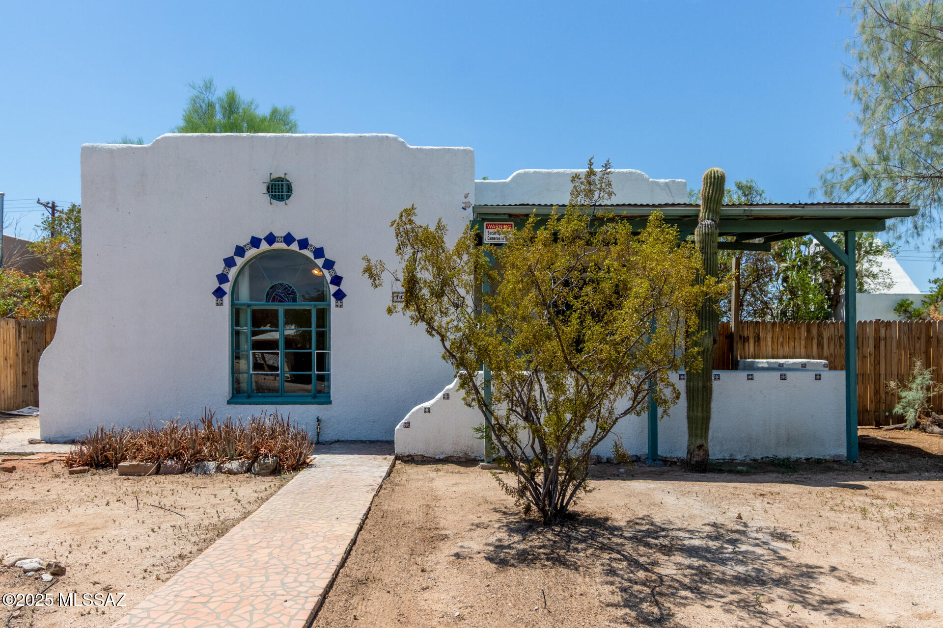Step into the timeless character of this beautiful 2BR 1930s home located just one block from the University of Arizona bike path. With its bungalow style stucco exterior, classic covered porch, and authentic architectural details, this gem exudes vintage Tucson charm inside and out. Inside, you'll find newly refinished hardwood floors, coved ceilings, and a cozy fireplace framed with custom tilework — all glowing with natural light from well-placed windows. The spacious layout offers flexible living and dining areas, perfect for relaxing or entertaining. The kitchen combines warmth and character with custom tile countertops, handcrafted accents, and modern stainless-steel appliances, all set atop rich Saltillo tile floors. Out back, enjoy the huge double-fenced yard offering privacy, space for entertaining, gardening, or even a future guest house. A detached garage provides storage or parking flexibility. And the roof on the home was just resealed and maintained (July 2025) for peace of mind. Whether you're looking for a historic home with soul or a smart investment near campus this is it!