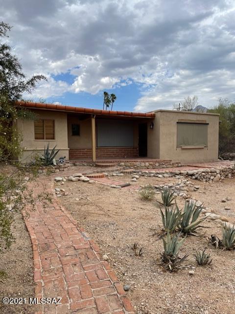 Unique Rustic Guest House on 2 desert acres. Like new inside - flooring, kitchen, bathrooms, doors, etc.  Office/Den. No carpet - tile & wood look floors.  Single Garage. Extra storage. Security Alarm. Walled yard with covered patio. Quiet tranquil surroundings with low care landscaping. One pet will be considered. Must see this property to appreciate!.