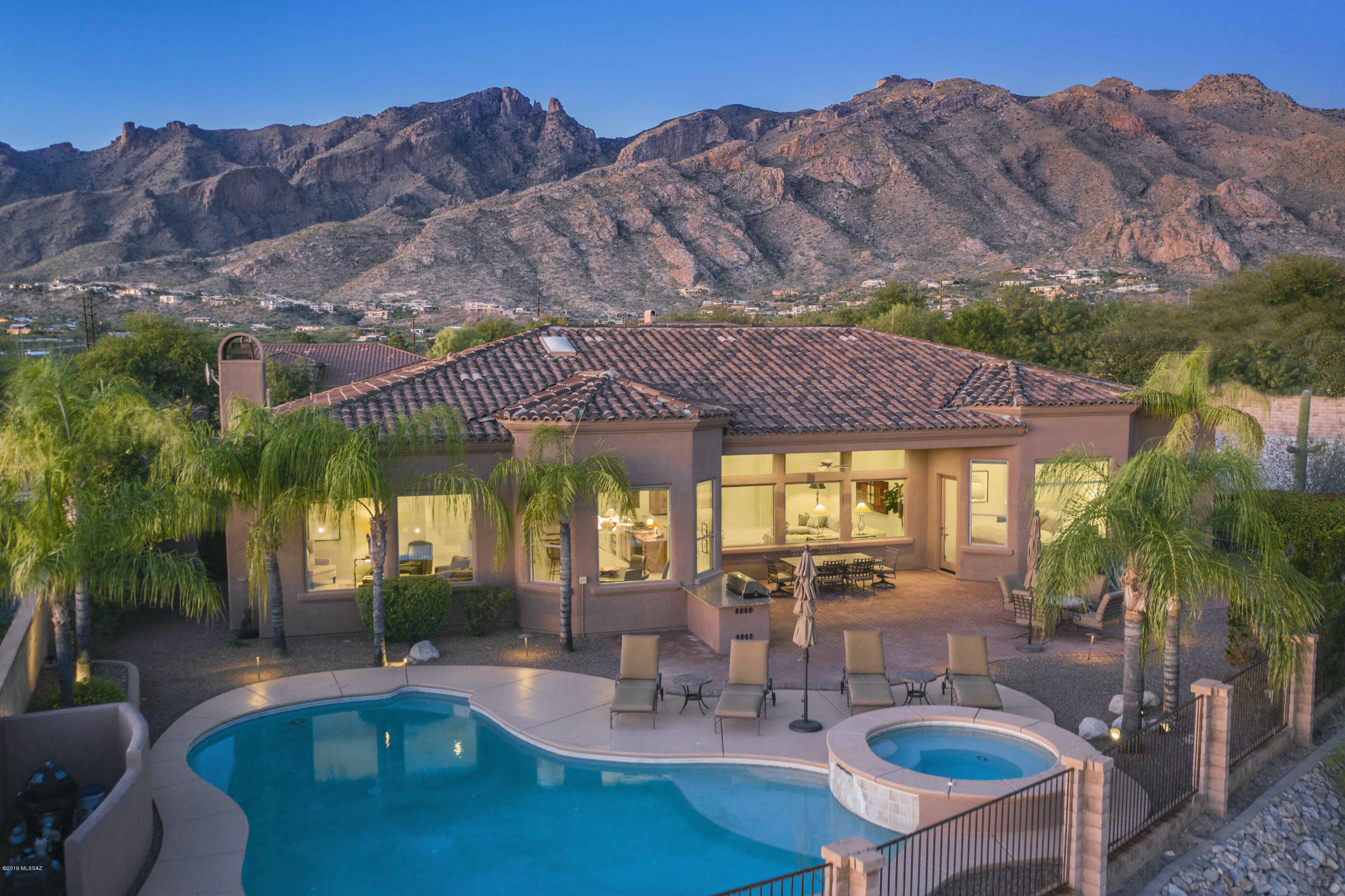 Stunning soft contemporary w/mountain, city & sunset views in desirable gated Pinnacle Ridge. Front courtyard  entry, exquisite living room w/high ceilings, walls of dramatic picture windows, formal dining room, gourmet island kitchen w/granite countertops, gas stove top, refrigerator, double ovens, pantry, large family room, lovely breakfast area that opens to family room w/fireplace,  beautiful tile flrs, 3 BR's+ study w/built in bookcases or 4 BR's, 4 baths including master w/sitting area, bath w/designer tile countertops, double sinks, garden tub, shower, 2 large walk in closets & private entry rear patio. Enjoy fabulous bkyd w/cov'd brick patio, pool, spa, BBQ, lush landscaping, 3 car garage,  Dist.16 school & incredible  city & mtn views. Floor plan under photos/virtual tour.