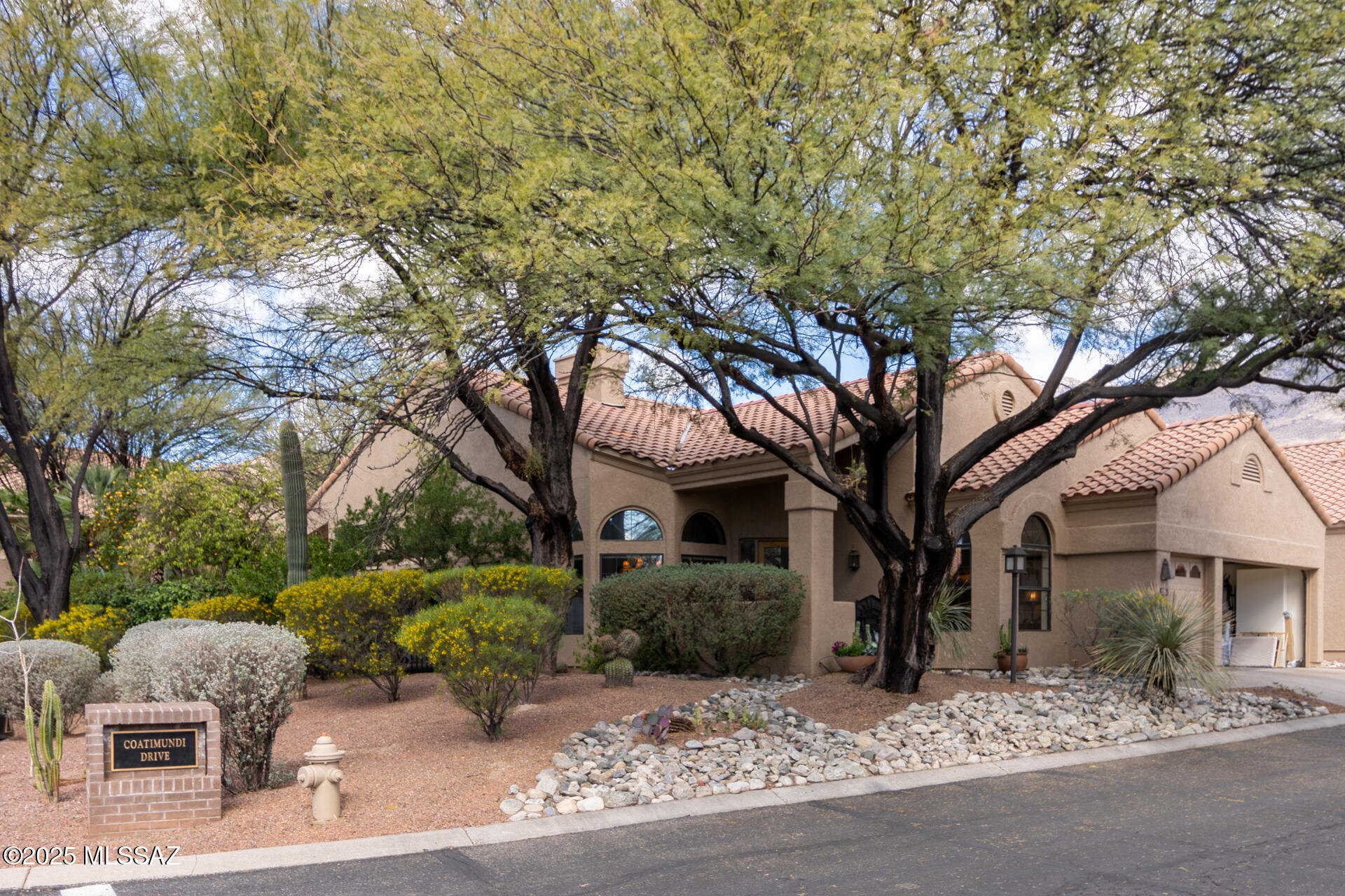 Extraordinary Golf Villa w/2.5 car garage including rare golf cart garage! Beautifully situated on an over-sized corner lot in prestigious Ventana Canyon Country Club! Comfort & space for all in 2BR/2BA, plus den, featuring a split plan, travertine floors & generous sized great rm,w/vaulted ceiling, stone fireplace, niches & bar-perfect for entertaining! Attractive kitchen, SS gas cooktop, window in breakfast area o/looking wrap a/rnd patio w/lush landscaping! Wall of window in dining area! Discover lg master ste w/double doors to spacious bath-impressively updated w/garden tub, travertine counters & custom walk-in-closet. Guest will love, tranquility, privacy & updated guest bath! Rare opportunity in spectacular community! Heated community pool, spa & Country Club memberships available