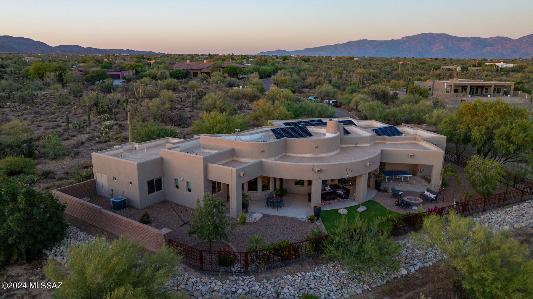 Situated on over an acre in Tucson's scenic landscape, this custom luxury home boasts a unique design and sweeping sunset views. The spacious backyard is ideal for entertaining with a wrap-around covered patio & firepit overlooking the desert sunset. Inside, the chef's kitchen is a standout feature, complemented by tall ceilings and ample natural light. The primary suite offers a luxurious bathroom with a walk-in shower, soaking tub, separate vanities, and three closets.  Additional highlights include owned solar, an oversized 3-car garage with 8'' ft doors and extended length (a single bay fits a full-sized truck), and RV parking with full hookups.  The seller is also open to seller-financing with agreeable terms. Contact us today to schedule a private showing!