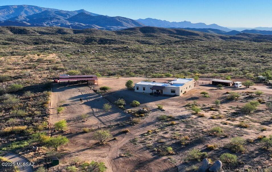 MAJOR PRICE REDUCTION!! Tucked away in small-town America, at the northern foothills of the Santa Catalinas the old mining town of Oracle is a visitors' outdoor activity destination, dotted with coffee cafes, pubs, eateries, a gourmet grocer & bakery and other essentials.  Inside, the custom solid quality home blends lodge-style design with rustic sophistication. Rich wood accents, large picture windows and 8' glass doors throughout create a seamless connection to the stunning unobstructed mountain landscape. Entertain or relax in the inviting courtyard with 1,250sf of covered patio and oversized fireplace; or indulge your culinary talent in the inspirational, professionally designed and appointed kitchen, boasting BRAND NEW high-end Viking & Thermador appliances and abundant natural stone counters atop custom wood cabinetry and a pantry. The split layout offers two oversized bedrooms plus a flexible bonus room that easily becomes an office, guest space, fitness room, or studio. Bathrooms are finished with quartz double-sink vanities, porcelain tile and spacious zero-threshold showers. At nearly 4,500 feet elevation, where the temperatures are consistently 10 degrees cooler than Tucson, Oro Valley, Marana and Tanque Verde, this property is where horses thrive, featuring thoughtfully executed equestrian facilities on the fully fenced and gated land, which were designed for the climate, efficiency and safety. The stables includes a barn with 5 oversized stalls, a tastefully appointed tack & feed room, pipe-fenced turnouts and separate exercise paddock. Beyond your fence line, a vast 750,000 acre network of hiking, biking and riding trails awaits in the State and National Forest lands, accessible directly from your property, giving this all-usable 3.34-acre equestrian retreat the kind of freedom and privacy for anyone craving space, solitude and the quintessential Arizona lifestyle in a relatively low-maintenance format, while still within reasonable distance to the University, businesses, shopping and services.  An outdoor shower, aromatic cedar spa, and two full RV hookups round out this amazing property. Come visit this impeccable, cultured comfort in Oracle. You'll be glad you did!