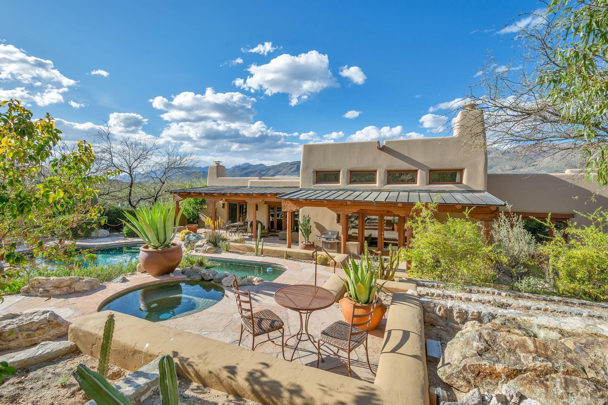 Authentic mud adobe Tucson Hacienda exquisitely finished throughout - rare combination of stunning, historical 'Old Presidio' authenticity coupled with updated finishes. This 5 bdrm 'gallery-like' masterpiece features SOLAR, Thomas Blee Carlyle floor-to-ceiling custom murals, viga & plank ceilings, a stunning yard oasis with a natural rock waterfall & landscape with specimen cacti from Plants of Distinction. Includes a charming gated front courtyard & fountain. Resort living inside and out, with dual master suites, 4 fireplaces, a spacious 461 sf gym/office/bonus room, new exterior paint, & stunning detail everywhere! Walk to Agua Caliente Park & Agua Caliente Hill Trail. This one-of-a-kind home was featured in Tucson Lifestyle Magazine - Previously on the mkt for over $2 million