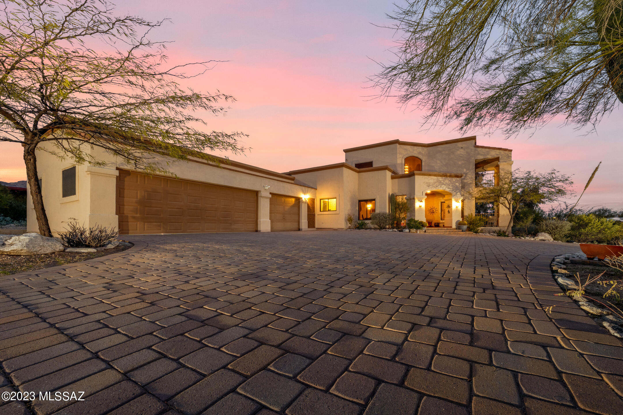 Incredible home with tasteful desert plantings, curb appeal, and a driveway covered in high-end pavers that lead to the entry of this gorgeous property. Step inside and notice plenty of natural light, high ceilings, and the staircase leading to the second floor. The kitchen features granite countertops,  stainless steel appliances, and wood cabinets that provide plenty of storage space. A wet bar with wine storage is plumbed and complements the kitchen area. China storage is located just to the side of the dining room.  
Primary bedroom has 9' ceilings, a fireplace to keep you warm, and 1 of the 5 balconies featured in the home that provide lovely views of Tucson and the mountains. Dual sinks with vanity lighting can be found in the primary bathroom as well as a garden tub and separate separate shower.
Whether you are looking to relax or entertain family and friends, the large backyard will provide many options - no matter the season. An extended covered patio has dual ceiling fans and gives plenty of shade.
A few extra features of this home include a central vacuum, reverse osmosis water system, owned water softener, and extra storage in the garage. Your next chapter starts here!