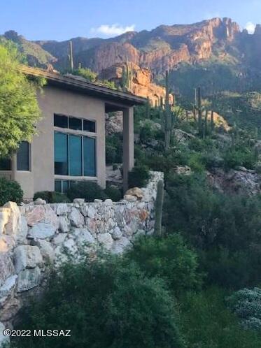 Immaculate contemporary home high above the city in  a gated community. This property backs up to the Coronado National Forest;  Premium lot  on the canyon with fantastic city, mountain, sunrise and sunset views from both inside and outside of the home.This home truly has it all! Tall ceilings (24 feet in Great Room!),  open floor plan, and floor to ceiling windows! Kitchen w/granite counters, stainless steel appliances, gas stove and wet bar.  2 gas fireplaces (1 in formal dining area and 2nd one in Great room)  Large Primary bed and bathroom , walk in closet with built-ins, 2 additional bedrooms  with jack n jill bath, plus  additional guest bath,  huge loft area with balcony  (can be used for many uses), multiple patio areas, built in BBQ  and over sized garage.   New Roof and A/C unit School District 16, Close Proximity to La Encantada Mall/ AJ's, near popular golf courses and walk out your door  to the Finger Rock Trails! Don't miss out on this one of a kind home! Schedule your showing today!