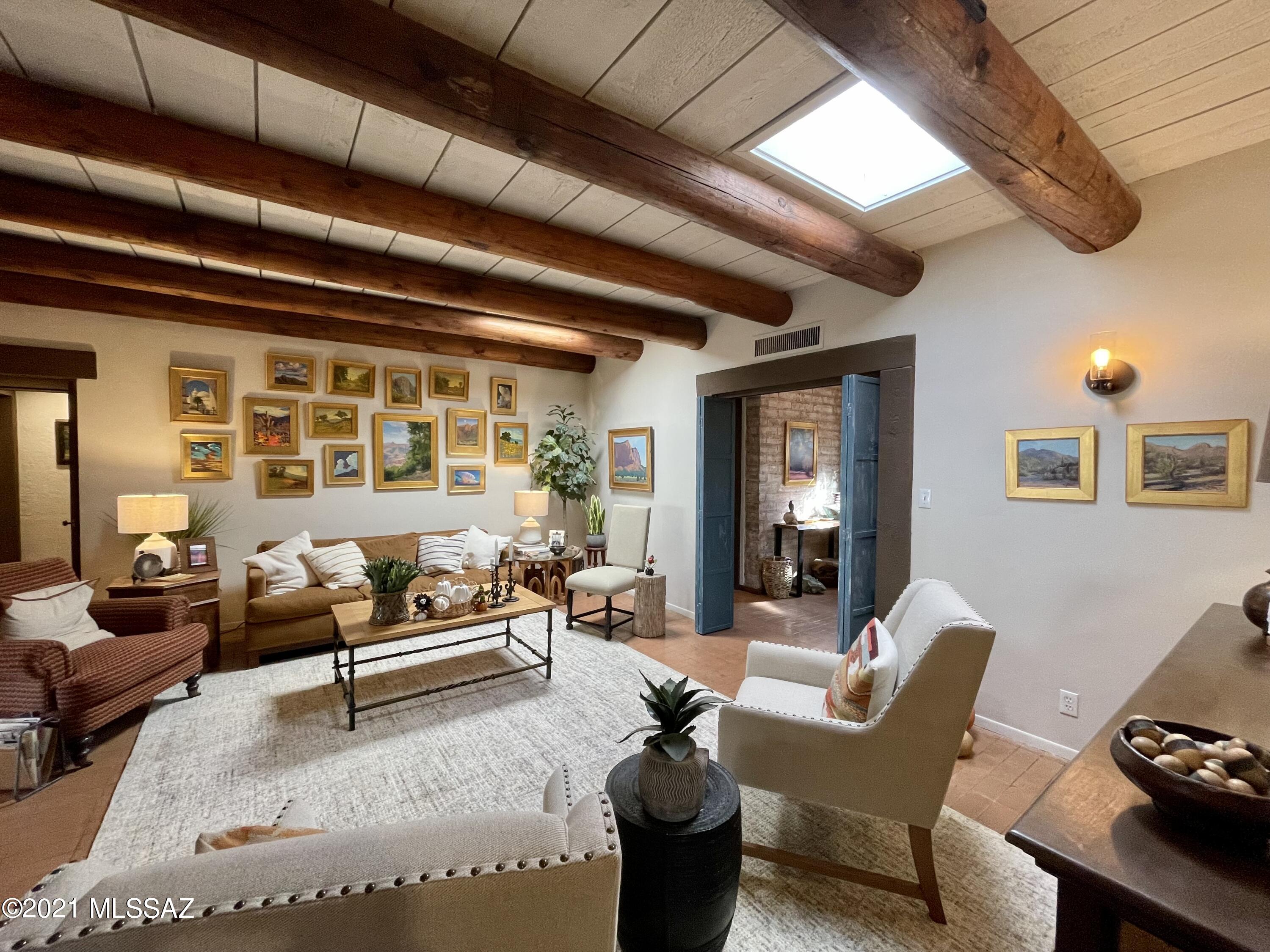 This substantial Territorial home has viga ceilings and exposed Adobe walls throughout. On a sprawling half acre lot in Historic Catalina Vista, this home offers five bedrooms, 4 bathrooms, an office, gym, and two full kitchens. Brick floors, wood ceilings, and Spanish tile all contribute to this remarkably warm and timeless residence.  The expansive living and dining spaces center around a large kiva fireplace and views of the central courtyard. The rear yard has a mature cactus garden, custom pool, and brick patios. All this just walking distance to the University of Arizona and Banner Hospital.