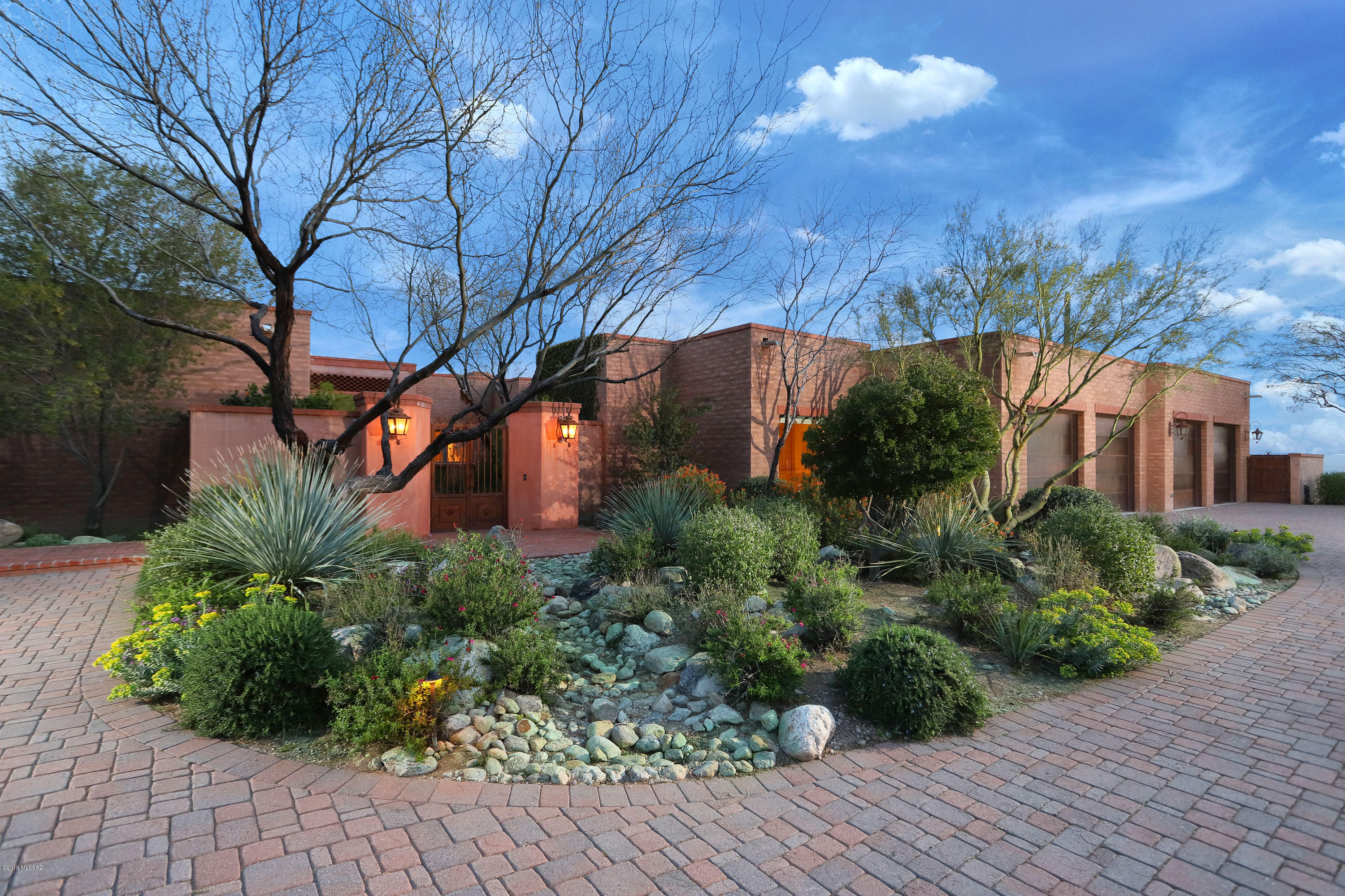 ''Casa Corazon.'' An Exquisitely Crafted La Quinta blt masonry home w/ tremendous city, mtn and lush desert views, nestled amongst Giant Saguaros within the second gate of Prestigious Pima Canyon Estates. Enter through the grand brick paver courtyard w/fountain into this Magnificent Home w/ sky high wood beamed ceilings and unparallel finishes throughout, including Egyptian limestone flrs, 4 travertine & 1 hand carved cantera fpls, flr to ceiling windows w/expansive views, Gourmet Island Kitchen, Alder Cabs, Granite cntrs, top of the line appliances and fabulous wet bar w/ refrigerated wine rm. Luxurious Master Suite w/fpl, jetted tub, sep. glass shower & spacious closets w/custom built-ins. Private salt water pool/spa & inviting outdoor living spaces. Incredible Photovoltaic Solar System Casa Corazon

We call 1902 E Sahuaro Blossom Place, "Corazon", being a La Quinta, it is a very solid and safe feeling house.  This is not a "stick" house.  The La Quinta Construction is solid masonry with fully insulated furred interiors.  The great architectural design is by Seaver Franks Architects.  It is the perfect energy efficient house for this beautiful Sonoran Desert environment. 

Living in Pima Canyon Estates is park living at its best and living in this home grants you some of the most spectacular views in the region.  The Tucson sunsets from this home are breathtaking. 

It is a good place for family, friends and guests. 

We have made several improvements to the property over the years we have been here: 

1.	We installed an economically and ecologically sound Photovoltaic Solar Energy System. 
a)	We chose 40 Sun King Solar Panels.  They are the best and carry a 25-year warranty.  No other manufacturer does this.  The system has always surpassed electrical production specified by the manufacturer.
b)	We chose to create a system that would run even when the power goes down.  That means that we installed two sets of inverters for the 12.5 kilowatt load generated by the forty panels.  One set are the grid tied Sunny Boy inverters and the other set are Sunny Island inverters which allow the system to operate in Island Mode off grid for hours or even days if necessary. 
c)	We achieved this by also installing a Generac 20 KW natural gas powered backup generator and a shed load system that can distribute the demand load according to a priority schedule with heating, air-conditioning, refrigeration and most lights at the top of the priority list.  We also included the entertainment outlets.  We have never experienced a blackout even though our neighbors, even those with solar, have. 
d)	Technicians for Sustainability (740-0736) installed and maintains the system.  This was the only company in Tucson willing to take on our design for the combined on grid/off grid capability. They are good people and very competent. 

2.	We installed a high-end water purification system made in Germany but serviced locally.  Because it is such a high-end system has not required any service in years.  It is not just a filtration system, it is also an electrolysis system as well.  This makes the water softer without any need of salt whatsoever.  There is still calcium in the water but it is highly reduced.  The system reduces chlorine and a myriad of other potentially harmful chemicals to healthy standards!  There is an additional sanitizing module. 

3.	There is a reverse osmosis/water rejuvenator system that is installed which provides drinking water to the kitchen sink drinking faucet and the ice maker in the freezer.  This takes the remaining particulate out of the water and then adds back calcium and magnesium at healthy and appropriate levels. 

4.	We converted the swimming pool to a salt water system from conventional chlorine.  This system is heated and creates chlorine in a manner that imitates Nature by converting salt (Sodium Chloride) into sodium and chlorine.  The levels of chlorine have never been at a level that smells or feels like conventional additive chlorine.  We also installed a Diatomaceaus Earth Filter which does an amazing job, you will see.  The water feels heavenly.   This system is maintained, once a week, by Pool Werx (323-3405).  They are nice people and know the system well.  They also maintain the courtyard fountain. 

5.	We have also done quite a bit of planting.  We have wonderful grapefruit and Myer's lemon trees planted in the walled courtyard off the living room and more lemon trees by the pool.  There is a weeping mulberry in the main courtyard that is especially beautiful and prolifically fruiting kumquat tree in the main courtyard as well.  We consume the fruit of all the fruiting trees.  They produce delicious fruit!  Mike Henekey is the owner of Henekey Landscaping (780-1980) which maintains the landscaping twice a month.

6.	In addition, we converted the original air conditioning system, which was a new 13 SEER system with three compressors to a 22-24 SEER Nutone IQ Inverter driven system.  This is a much more efficient system that allows the solar power system to net meter most of the year with our current usage i.e. around $7 a month during most months.  We have a great guy, George Kelly, owner of Kelly Mechanical and Air Conditioning, who is a certified Nutone technician, who maintains the system.  The system has between two to three years remaining on its warranty.  He last serviced and inspected the system on 4/8/2017.  The system also has American Standard electrostatic auto air filtration which keeps the air in the house very clean. 

7.	We also recently upgraded the whole wine room system.  Hamstra Heating and Air Conditioning (629-9833) installed both the original system and the new system and will maintain the system.  The new system is also under warranty.

8.	There are five spectacular real masonry fireplaces in this home.  Such pieces of masonry art are very hard to find.  Every one of them is done in a herringbone brick pattern.  The living room, master bedroom and office/guestroom fireplaces are furnished with remote controlled thermostatic gas logs installed by the Flame Connection (623-0626).  The family room and the outdoor living room are furnished only for wood burning.  It is nice to have the choice on a chilly evening. 

9.	The cable TV/Internet connection is supplied by Comcast Xfinity.  Xfinity provides the fastest internet available in the region.  Nearly every room in the house has a full active ethernet connection with speeds up to 150 mbps.  We also use two Apple Airport wireless routers in a unified Wi-Fi system with speeds up to 100 mbps throughout the house.  We have found that Xfinity customer service has become much more responsive over the last couple of years and they have been quite attentive to our needs on those few occasisons when we have called them. 

10.	The Office/Guest Room has been enhanced with a beautiful ensemble which includes three extra workspace areas and a queen sized Tempurpedic Cloud Supreme Murphy bed.  It is simple to push back the desk and drop the very comfortable bed down. 

11.	Corazon has been improved and maintained to the highest standards.  All systems are current in their maintenance schedules. 
â€ƒ
EXTERIOR

â€¢	Mortar washed slump block with integral color plaster
â€¢	Exterior wall sconces and chandeliers-hand forged iron from Mexico 
â€¢	Exterior gates-hand forged wrought iron
â€¢	Brick courtyards and patios
â€¢	Hand carved Cantera fireplace in outdoor living room
â€¢	Outdoor kitchen
â€¢	Decorative tile in pool, spa and fountain from Dolores Hildalgo, Guanajuato, Mexico


INTERIOR

â€¢	24" x 24" Egyptian limestone floor tiles
â€¢	Hand carved travertine fireplaces
â€¢	Alder cabinets
â€¢	Custom designed and hand carved alder island and powder room vanity from San Miguel De Allende, Guanajuato, Mexico
â€¢	Smaller powder room cabinet is rosewood
â€¢	Imported hand carved mirrors in all bathrooms
â€¢	Pewter wrapped carved mirrors in master bath
â€¢	Jason tub with air jets in master bath 
â€¢	Cast iron tubs in guest baths
â€¢	Marble countertops in all bathrooms 
â€¢	Granite countertops in kitchen, wet bar and pantry 
â€¢	Kitchen appliances:  Wolf 48" dual fuel range with griddle, Wolf convection microwave, Wolf 30" warming drawer, Asko dishwasher, 42" Sub-Zero refrigerator 
â€¢	Wet bar appliances:  Fisher Paykel dish drawer, Uline under counter refrigerator with ice maker
â€¢	Walk in refrigerated wine room with custom alder wine storage system 
â€¢	Handcrafted chandeliers and wall sconces from Mexico
â€¢	Decorative tile in kitchen and bathrooms from Dolores Hidalgo, Guanajuato, Mexico 





Information provided by Seller is deemed reliable but not guaranteed.
