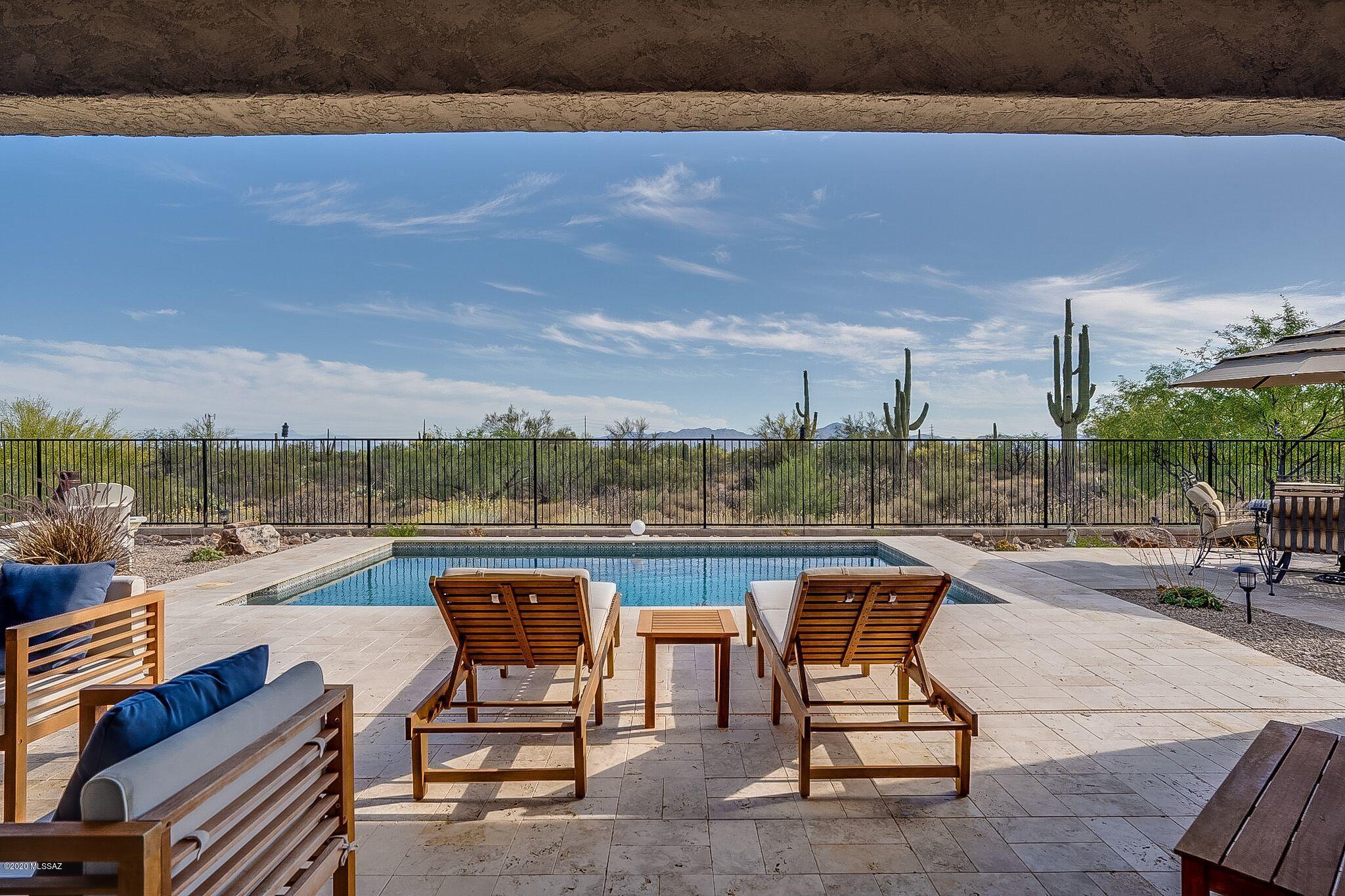 Spectacular, one of a kind desert estate property located on a 3/4 acre nature preserve lot in prestigious, gated Tortolita Vistas. Views views views out of every window! No neighbors behind and huge space between homes. 4 car garage, (two-2 car). Very private and quiet. Nearly 3,700 s.f. on one level. Less than 3 years new, this home is perfect in every way and has incredible indoor/outdoor entertaining areas. Backyard finished in natural travertine pavers, with pebble sheen pool, built-in BBQ, Talavera bar area with seating for 8, flat-panel TV, dining area, sofa, loveseat and 180-degree mountain & city light views. 4 bed, 3 bath, game room/den with bar & built-in beverage cooler, separate library/office/study, walk-in rainfall shower in master, his/hers vanities. Please see supplement Stunning ¾ acre preserve view lot filled with mature saguaros, mesquite and palo verde trees and spectacular desert landscape. Best of all, no neighbors behind and huge space between homes.
Twinkling nightime city light views and mountain views from every direction.
Prestigious gated community with low HOA fees and huge open space between homes.
One level, 3,689 s.f., 4 Bedrooms, all with walk-in closets, 3 full baths, office/study, living room, game room/den plus rare two separate 2 car garages, Spanish hand troweled finish on all walls and ceilings.
Amazing outdoor living areas with custom Pebble Sheen below ground pool with natural travertine paver pool deck and pool umbrella and volleyball sleeves. Talavera outdoor bar with seating for 8 and built-in Louisiana BBQ grill included. Separate natural travertine patio area for dining table and chairs.  Covered natural travertine patio area with 42" flat panel TV (included with cover and wired for cable), 2 built-in ceiling mounted speakers and 72" Fanimation commercial 9 blade ceiling fan with remote and recessed lights. 
10' ceilings and 8' interior doors through entire house.
Center pull 12' wide sliding doors to backyard.
Open kitchen/family/dining concept. Whole house speaker system with 5.1 surround in family room. One touch button gas fireplace in family room with rustic wood mantle and corbels. Wireless waypoint for extended WiFi coverage.
GE profile double ovens, DW, Microwave, 5 burner gas cooktop and pro hood all finished in stainless steel. A Whirlpool counter depth, French door, bottom freezer refrigerator is included. Massive kitchen island with cabinets on both sides and seating for up to six. Imported Italian old world wrought iron pendant chandeliers and Italian tile backsplash. Hansgrohe Cento commercial kitchen faucet.
The huge game room/den includes  5.1 surround and dry bar with built-in beverage cooler and exotic granite countertops.
Impressive formal entry with Italian old world wrought iron chandelier, curved wall and mosaic floor.
High quality Minka Aire fans in all rooms and recessed lighting throughout