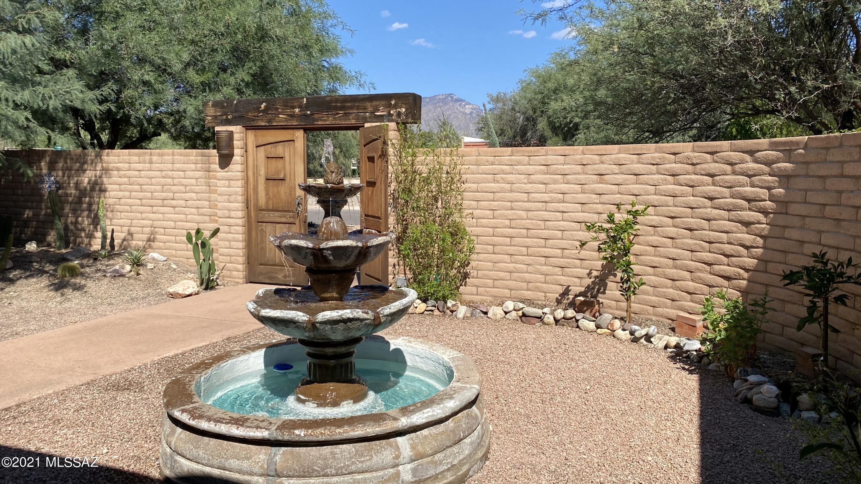 Walk through the double wood doors to the private courtyard. Relax on the front patio with your favorite beverage while you view gorgeous Southern AZ sunrises/sunsets, majestic mountains & the tranquil sounds of the fountain. The front patio leads you into the open den & kitchen area w newer white kitchen cabinets, concrete countertops & stainless steel appliances. 3 bedrooms w 2 updated bathrooms. Living/dining room in the back of the house leading out to the extended covered patio & oasis backyard w sparkling pool, grassy area & 3rd covered patio. Plenty of parking on the concrete driveway leading to your 2 car garage, 3 car carport & storage area. This home provides ample indoor/outdoor living for entertaining family & friends for the upcoming holidays. Check out 3-D Tour!