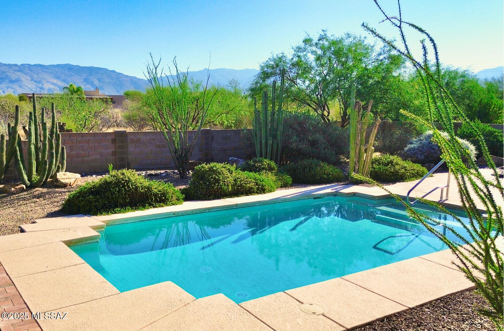 Pool and hot tub with open space and mountain views. High ceilings. 5 bedrooms / 3 bathrooms. 3-car garage. Interior guest quarters includes a bedroom, bathroom, living room, and kitchenette. Beautiful tile throughout. Main kitchen offers plenty of cabinet space and a gas cooktop.