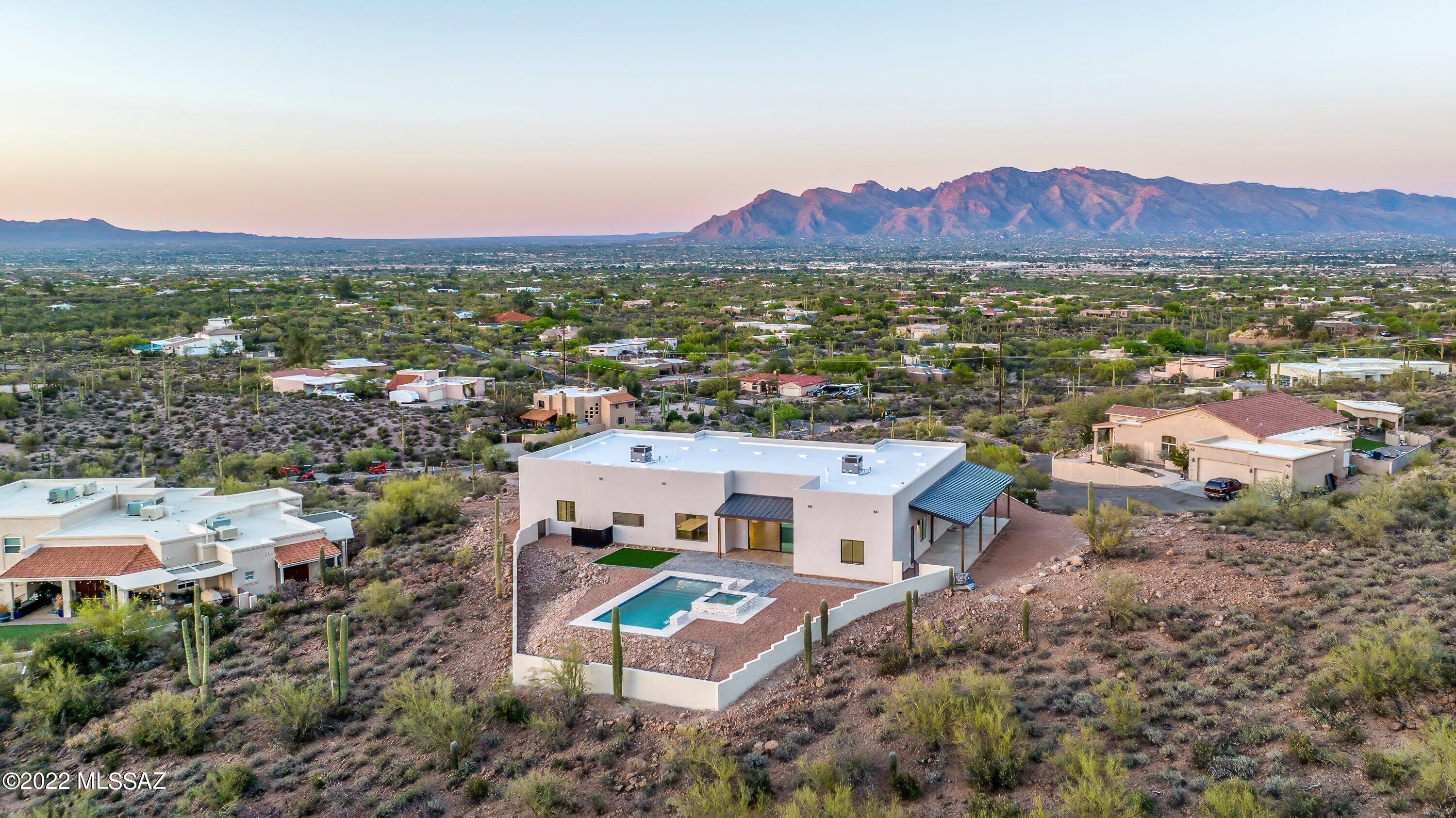 Take a look at this home with unobstructed 360 degrees views. This contemporary desert custom home features countless luxury upgrades with soaring 12ft celling's. sitting on a 3.3 hillside acre lot, catching cultivating sunrises, sunsets, mountains, and city lights. Leading to the home you have a 400ft stamped concrete driveway. Walking into the kitchen you are greeted with a massive 10ft center island, you will find custom made alder wood cabinetry with a 48inch gas rage, built in fridge, plus a wet bar. Quartz countertops completes the look of this modern kitchen. You get an indoor-outdoor feel with an 8x12 sliding door, once outside you have a heated pool to be enjoyed year-round. Don't wait schedule your showing today before it's gone.