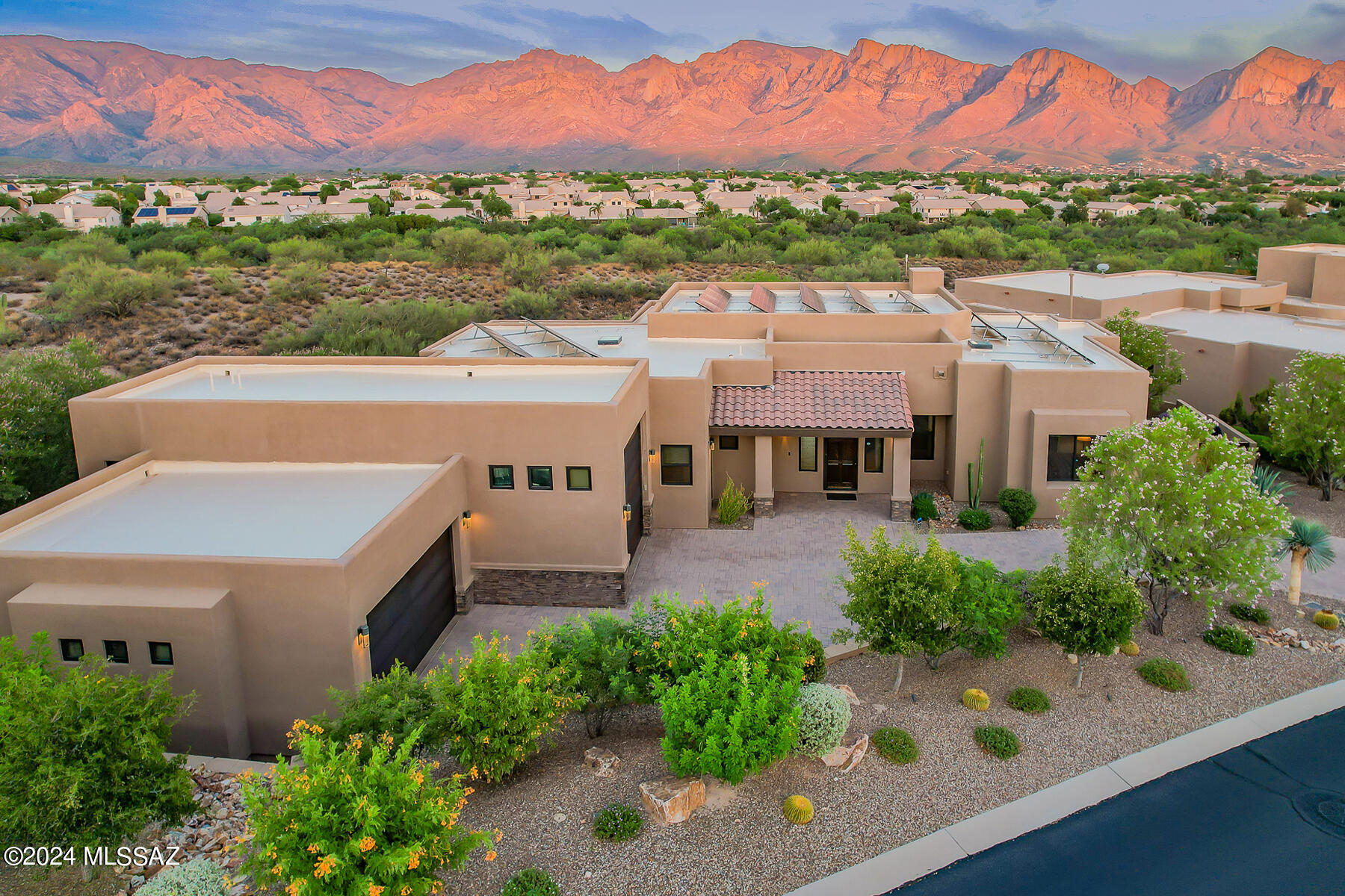 SPECTACULAR CUSTOM LUXURY HOME on 1.2 acres in gated Vistoso Pointe at Rancho Vistoso boasts panoramic East facing views of the Catalinas with no one directly behind. This exquisite 3BD/2.5BA (2,518 sq ft) highly upgraded home also boasts owned Solar with current surplus, 3 en-suite bedrooms, 3 patios, heated/cooled 2-car garage plus attached RV garage, hot tub and outdoor shower, plus app-controlled amenities. Enter to find a split bedroom plan with ceramic plank tile, granite countertops and clerestory windows throughout, dual 2' x 2' skylights with power shades in hallways, Hunter Douglas power roller shades, 8' knotty alder doors and overheight Big Creek knotty walnut cabinets. Open concept plan is highlighted by soaring ceilings, 8' Andersen view windows and 12' slider (both Smart Sun Glass), floor-to-ceiling stacked stone gas fireplace, plus ceiling speakers/surround sound. Gourmet kitchen is highlighted by a curved center island with breakfast bar, breakfast nook, stainless Monogram 42" refrigerator, induction cooktop with exhaust fan, Monogram Advantium microwave/convection and speed cook ovens, plus Zephyr beverage center. Owner's suite off private patio with hot tub & wall shower hosts dual walk-in closets, dual vanities and large walk-in shower with pebbled floor and rain head/back massage/handheld showerheads. Front guest room plus rear third bedroom (or office) access a walkthrough bath with dual sink vanity and glass enclosed, tiled walk-in shower with pebbled floor and rain head. Additional powder room with floating vanity and vessel sink, plus laundry/mudroom offering overheight countertop and sink, storage cabinets, refrigerator/freezer, bench seat and drop-n-go station in hallway. Countless additional features include fire sprinklers, central vacuum, alarm system, water softener/purifier, whole house air filtration, tankless water heater with instant hot water and zoned heating & cooling. Retreat to a fabulous outdoor setting featuring covered main patio, walkway to private Owner's suite patio with hot tub and shower, plus lower patio with linear firepit, each overlooking the open desert behind offering spectacular mountain and sunset views. Grounds are meticulously landscaped with flowering shrubs, desert plantings, trees, decorative turf, stone cactus, seven arm fountain and pavers front and rear. Extended, epoxy coated garage is loaded with built-in cabinets, overhead racks, workbench, Slotwall and storage system. RV bay is equipped with a 50A circuit for motorhome which can be downgraded to 30A for RV or EV charger, plus RV sewer dump clean-out. Perfect for the most discerning buyer!