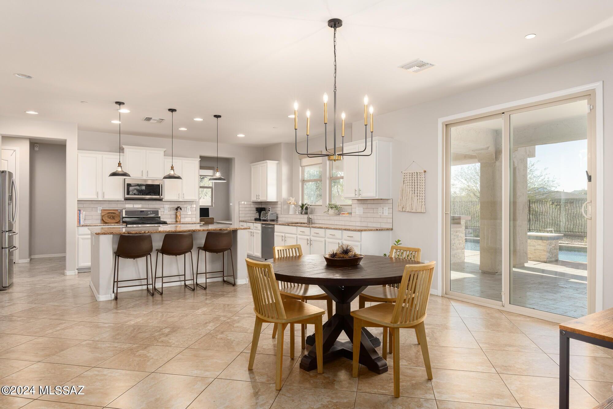 Discover luxury living in this stunning 4-bed plus den & bonus room that offers Catalina and Tortolita mountain views with no rear neighbors! The light-filled kitchen seamlessly connects to the great room, dining room, and den. Granite countertops, gas cooktop, a spacious island, roll-out drawer cabinets, a large walk-in pantry, and an office adjacent to the kitchen elevate your daily living experience. Sliding glass doors reveal your backyard oasis, complete with a pebble tec pool, spa, and basketball court. Outdoor entertaining is a breeze on the covered patio showcasing a built-in kitchen, countertop seating and room for additional dining or lounge space. Upstairs awaits a haven with 4 bedrooms, 3 bathrooms, laundry room, and a loft/media room featuring a projector and screen. The primary suite boasts a large balcony with sunset views of Honeybee Canyon and the Tortolitas. The primary bath is a retreat with double sinks, a vanity, soaking tub, separate shower, 2 walk-in closets, and a bonus room currently serving as an exercise room.
Outdoor entertaining is a breeze on the covered patio, showcasing a built-in kitchen with a Blaze BBQ, double side burner, warming drawers, sink, and refrigerator. The 3-car attached garage with epoxy floors includes an extended-length 2-car stall and a 3rd stall with cabinets for additional storage. Convenient location with easy access to bike trails, Vistoso Plaza, OV Marketplace & Hospital, parks and more!
