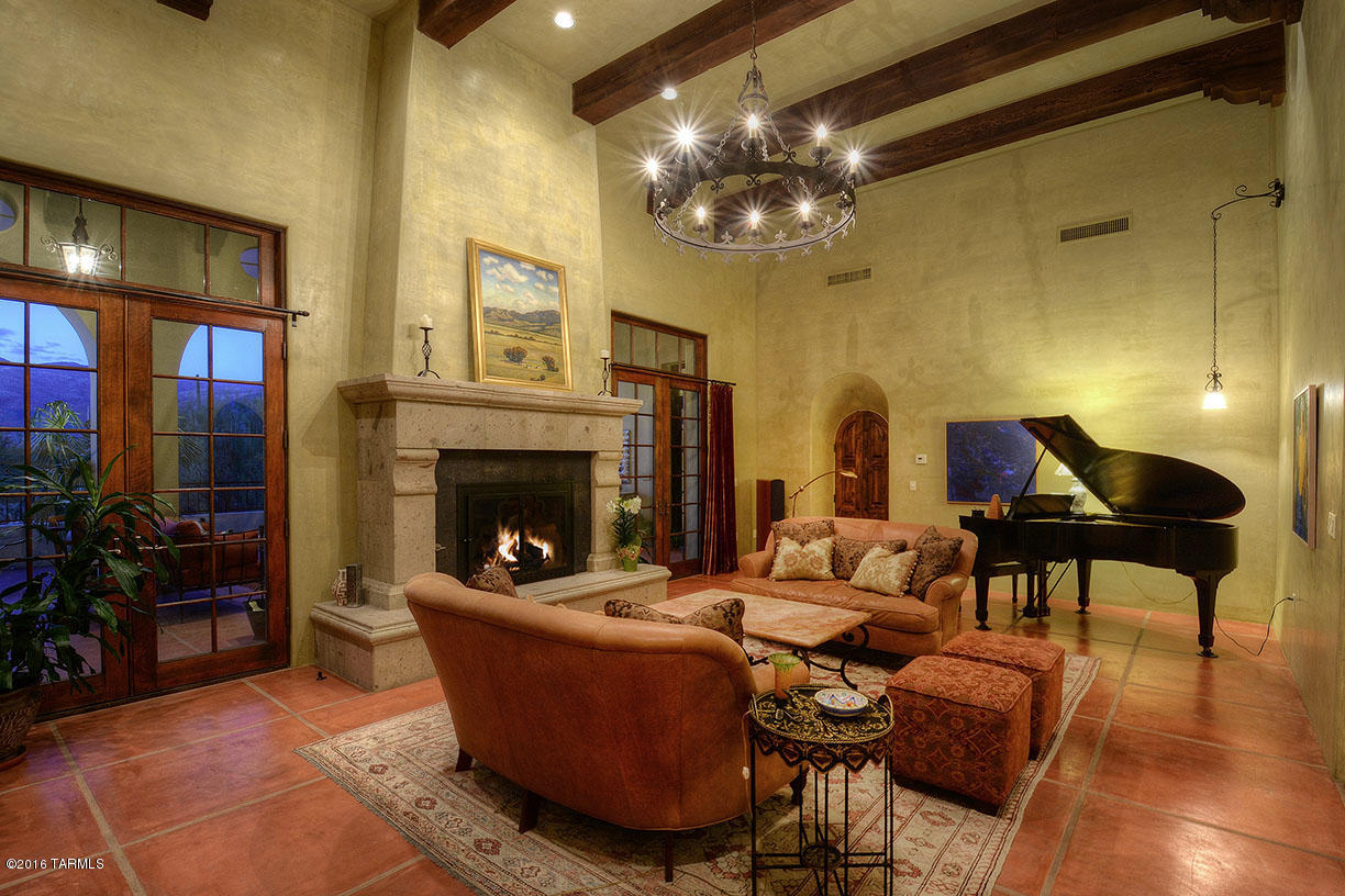 Inspired by the historic Spanish Colonial architecture of San Miguel de Allende, Mexico and sustainable solar and renewable technology of today, this remarkable and charming hacienda style home with an ''H'' configuration is located on 3 lush view acres in popular Palo Verde Rancho on Tucson's NE side. Enter the compound through a 100 year old wrought iron Mexican gate into the garden courtyard leading through arched French doors to the gallery of the 4,742 sq. ft. home with four bedrooms (office could be 4th bedroom) plus guest casita and studio. Stuccoed Rastra block walls exterior walls, Venetian plastered interior walls, living room with soaring 16' beamed ceiling, canterra stone and masonry fireplace, custom made bookcase and French doors leading onto the outside loggia with three arches framing the mountain views. Gourmet kitchen, glorious master suite with private outdoor spa, three car garage, solar system and pool. A remarkable, must see "Home as Art" creation.