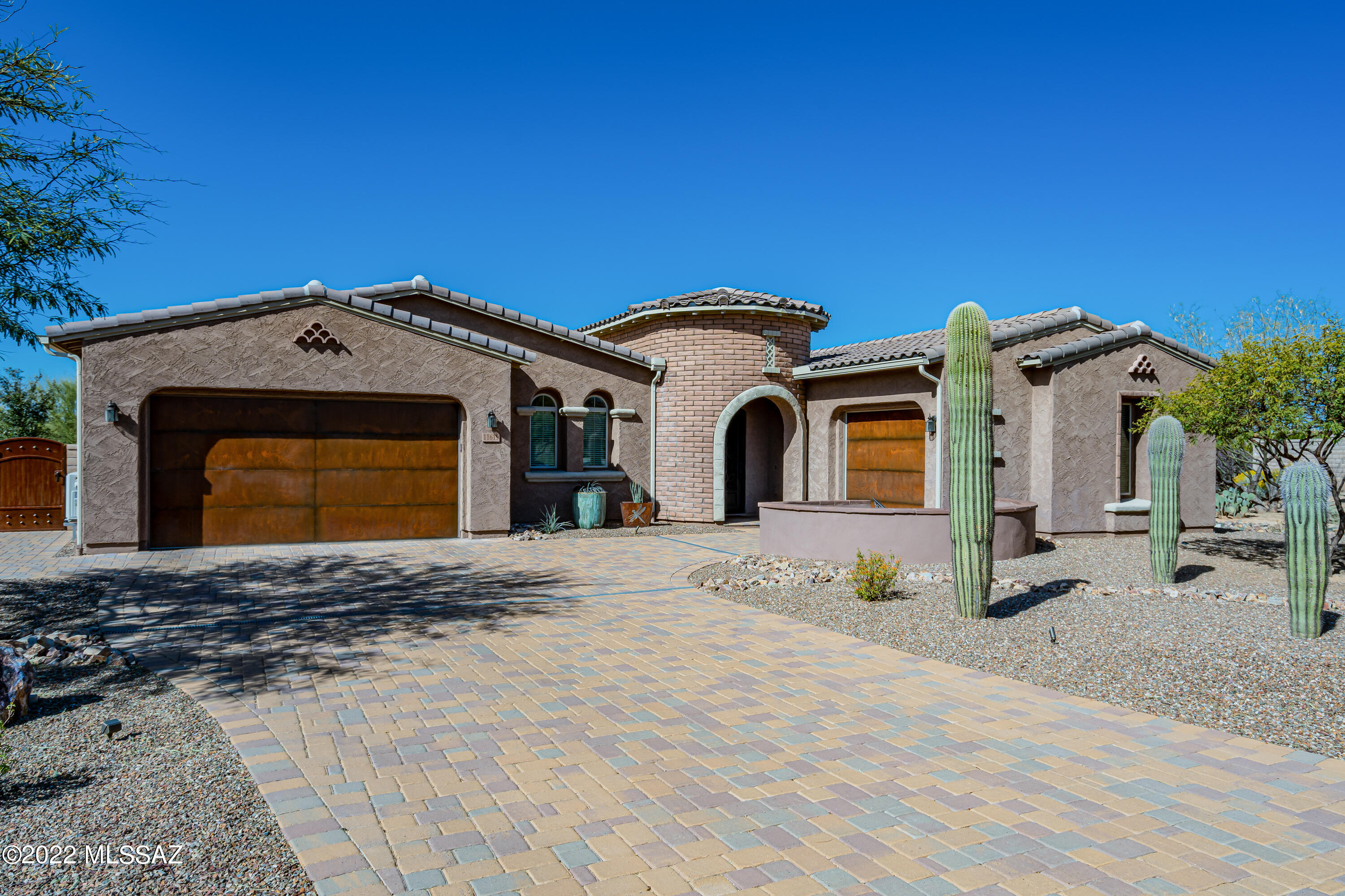 This jewel of a home is in the desirable gated community of Rancho Del Cobre.  From the private cul de sac lot, the home greets you with a tastefully landscaped yard, rustic metal garage doors, and a stately turret.  View the stunning Catalinas from the front patio, then enter through a dramatic iron and glass door to find a beautifully appointed home.  Gourmet kitchen boasts double ovens, granite counters, stainless appliances, subway tile backsplash and a generous island.  The den has an impressive brick accent wall.  The great room and den also feature built-in cabinetry. Large owner's suite has enviable his and hers closets you will love.  Back patio with inviting ramada has a built in BBQ and concrete bar; perfect for entertaining and enjoying the sunsets.  A wonderfully unique home!