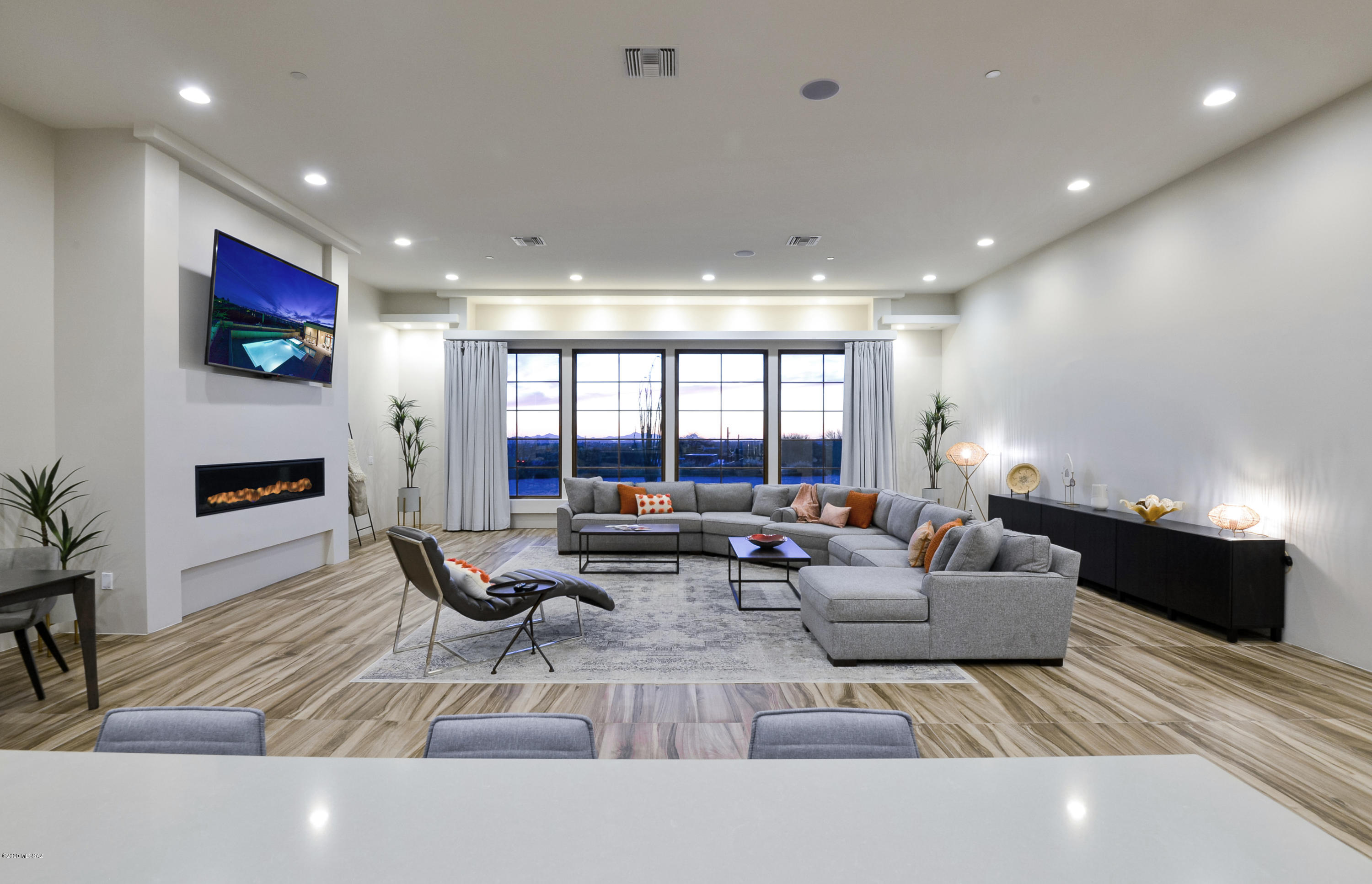 Stunning new great room style contemporary with supersized garage for 5-8 vehicles! Elevated corner lot with large circular paver driveway, resort style pool & spa, Catalina Mountain views and no HOA! Open layout with 12' ceilings creates sense of clean, crisp design. Luxury amenities, tile floors throughout except 3 rooms, split layout and Pella windows & doors. Upscale appointments of gourmet kitchen are showcased by the architectural design of the window wall overlooking the valley below. Butler's pantry includes wet bar. Master suite is true sanctuary with spa-like bath, walk-in rain shower, 2 huge closets and patio access. Formal powder room, 2 guest suites, den, laundry and half bath in garage. Private yard with spacious covered patio and pool with negative edge spa. Simply amazing!