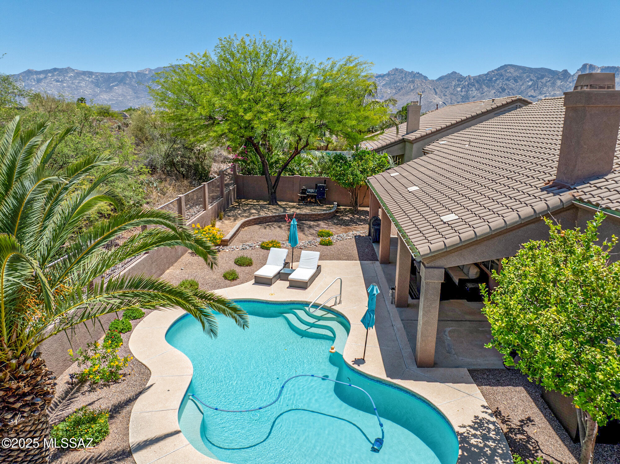 Timelessly updated home on a premium lot —backing to open common space for added privacy. This 3-bedroom split floor plan includes a private den, high ceilings, neutral tile throughout (no carpet), and a spacious open layout. The kitchen features knotty alder cabinetry, leathered quartzite countertops, a large island, a 6-burner gas cooktop—and a wet bar for entertaining. The owner's suite offers a soaking tub, walk-in shower, granite counters, LED backlit mirrors, a chandelier, and custom closet built-ins. Enjoy the travertine-faced gas fireplace, 3-car garage with added storage, and a sparkling self-cleaning pool, with recently added electric for a hot tub on the patio.  Seller shall credit $2500 for refrigerator until 8/31/2025.