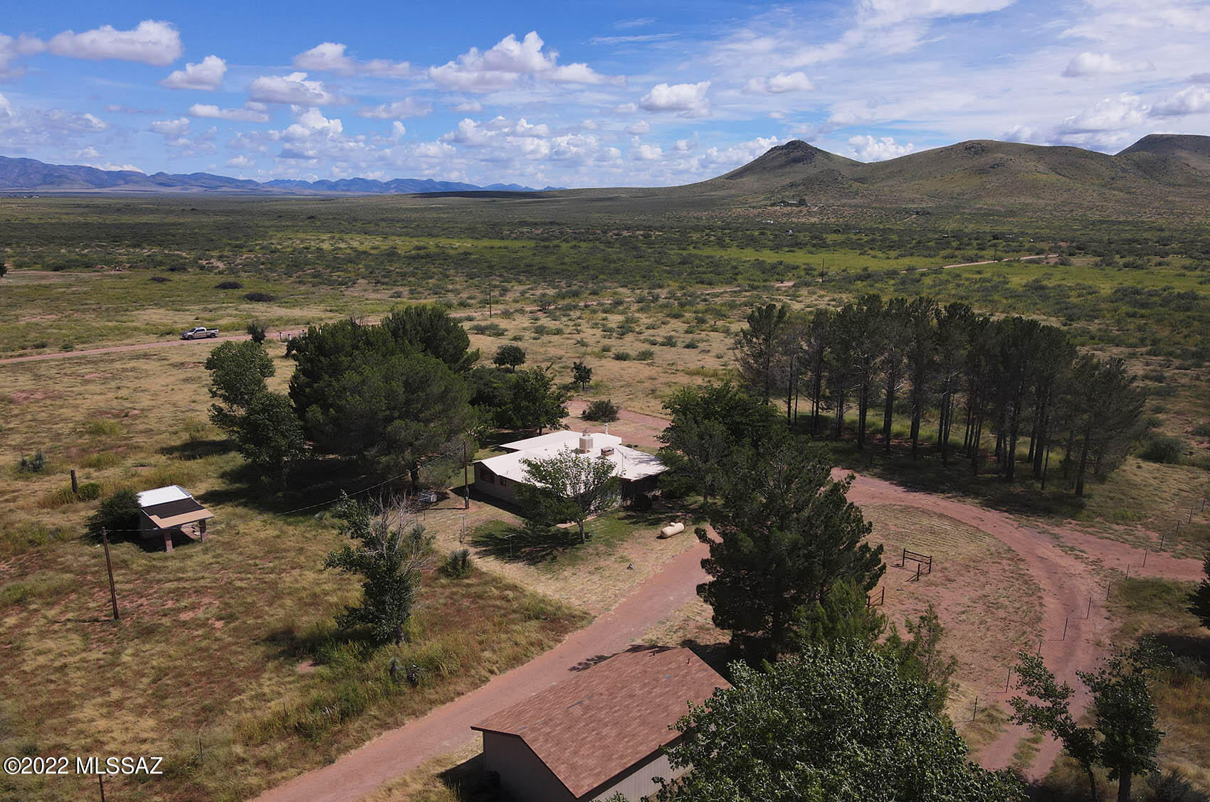 Priced to sell! Cozy & secluded well-maintained family home on 30 acres with additional acreage available.  Beautiful country property with mature trees and exceptional views of the Chiricahua Mtns & Flat Top Hills. Detached 32' x 20' shop/garage with 1/2 bath and roll-up door. Includes well house with recently upgraded well, shared with the home to the north. Unique features abound including wood stove and 2-sided fireplace/grill. Dedicated laundry and plenty of interior storage. Includes an extra room for office or guests. Outdoor gazebo and grill area for cooking, hosting and entertaining. Two screen-enclosed porches to enjoy the mild weather. A hobby orchard with many varietals of fruit & nut trees and irrigation system to water. Plenty of room to spread out and enjoy country living Adjoining 20 acre parcel to the west (Cochise APN: 401-70-011A) and 40 acre parcel to the south (Cochise APN: 401-70-015) are for sale by listing agent.  Up to 90 total contiguous acres available.
