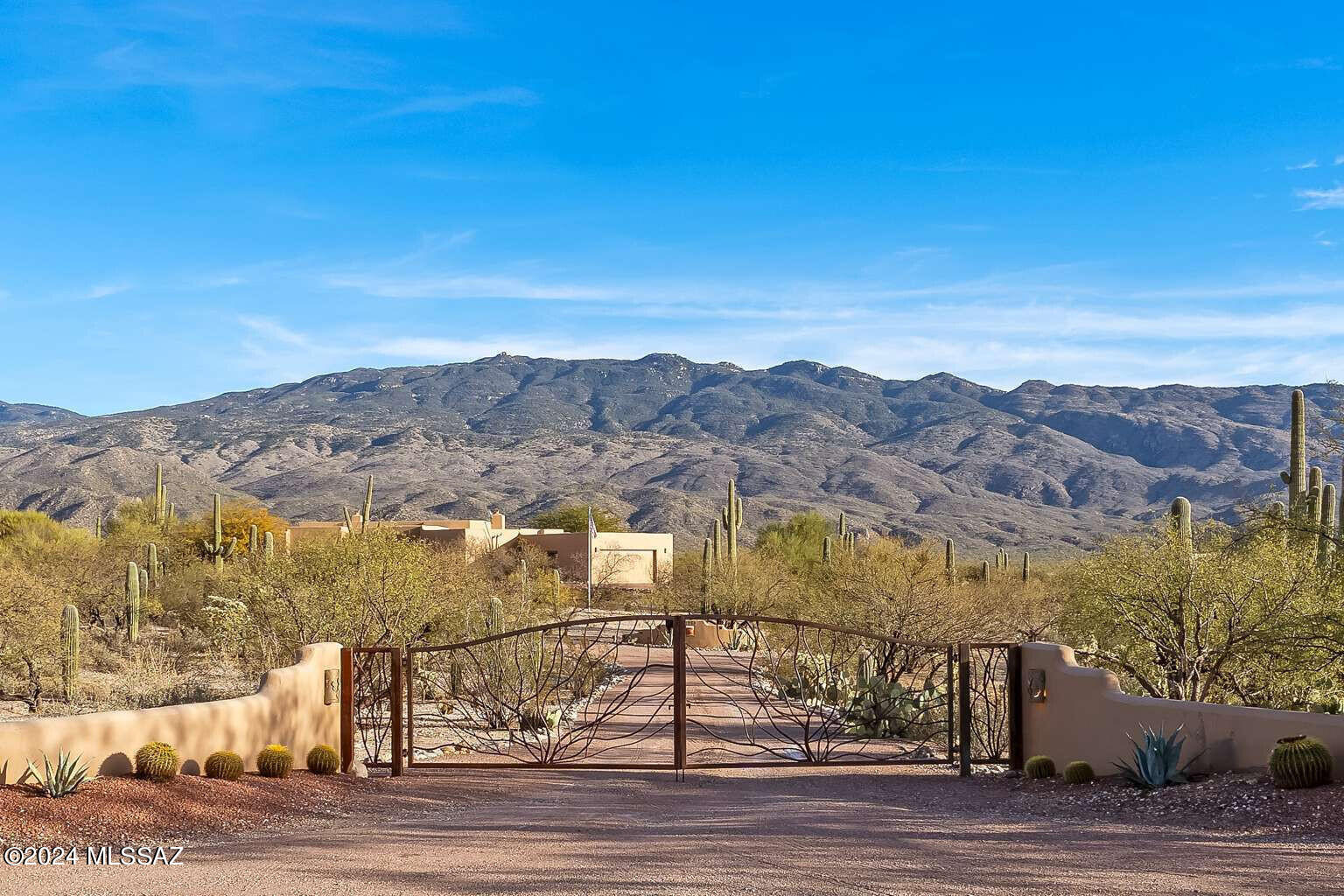 Beautiful horse property between the Rincons and the Catalinas with Southwestern Charm. Large windows with exceptional views of the mountains, four bedrooms plus an office, 3.5 baths, Saltillo tile floors and wood floor in the main bedroom. Vaulted wood ceilings with log beams in entry and living room, fireplace in living room and main bedroom. Granite countertops in the kitchen and 3 bathrooms. Professionally designed and landscaped front courtyard and backyard with timer lights and covered patio. Also, spectacular view of the Rincons! Pool and spa with colored lights, waterfall, firebowls, BBQ, TV and refrigerator. Lower outside patio with stone fireplace. Two stall barn w/lights, auto. waterer, storage sheds & round corral.