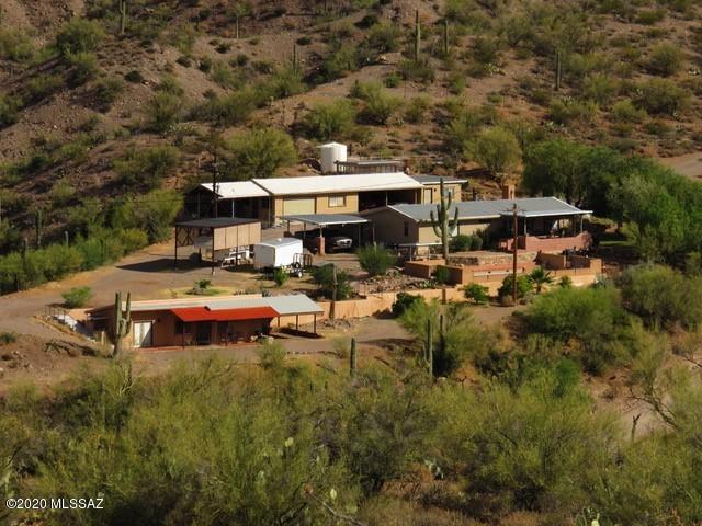 This spectacular property in Aravaipa Canyon has more amenities than you can imagine.  The home has been lovingly cared for which show in every room.  Every window in the main house has been replaced with Low E glass. There is a lovely guest house with kitchen from IKEA.  The landscaping and the views are beautiful.  There is a large workshop with AC, a beautiful lap pool, and carports.  All the comforts of indoor/outdoor living.  Come take a look at this little piece of paradise in Aravaipa Canyon.